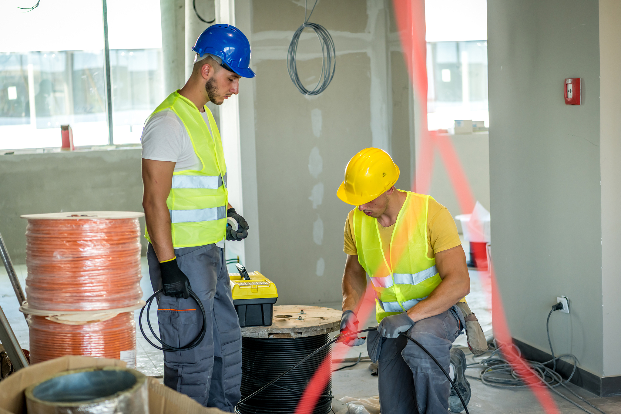 two electricians in a room under construction