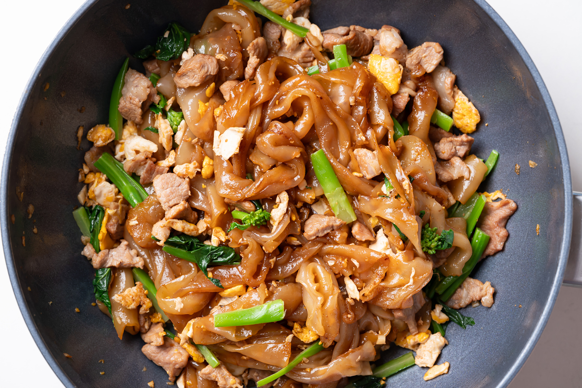 泰式炒河粉(pad see ew),锅中炒制酱油,猪肉,鸡蛋和的