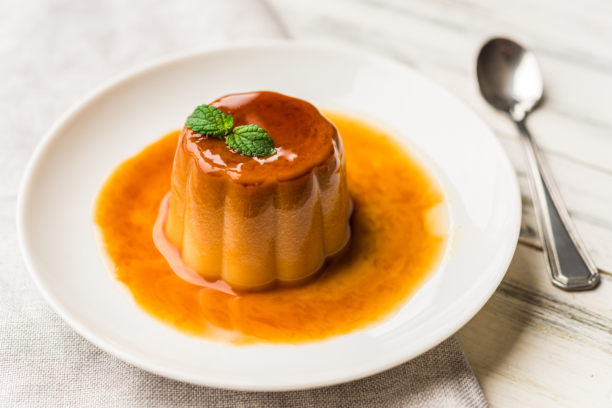 close up of a flan creme caramel pudding with mint, a custard de
