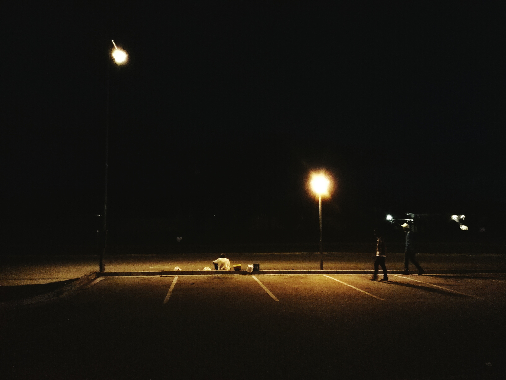 three people on parking lot at night