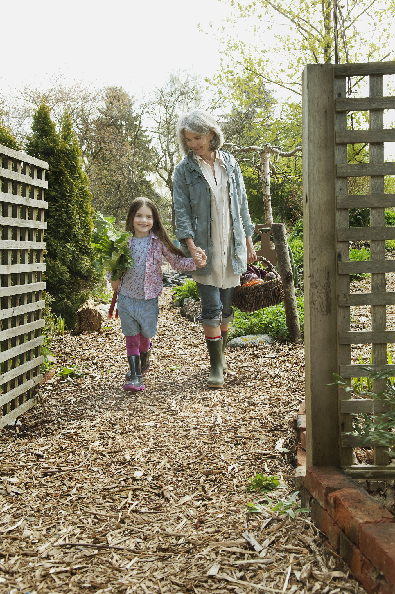 woman walking with granddaughter in a vegetable garden