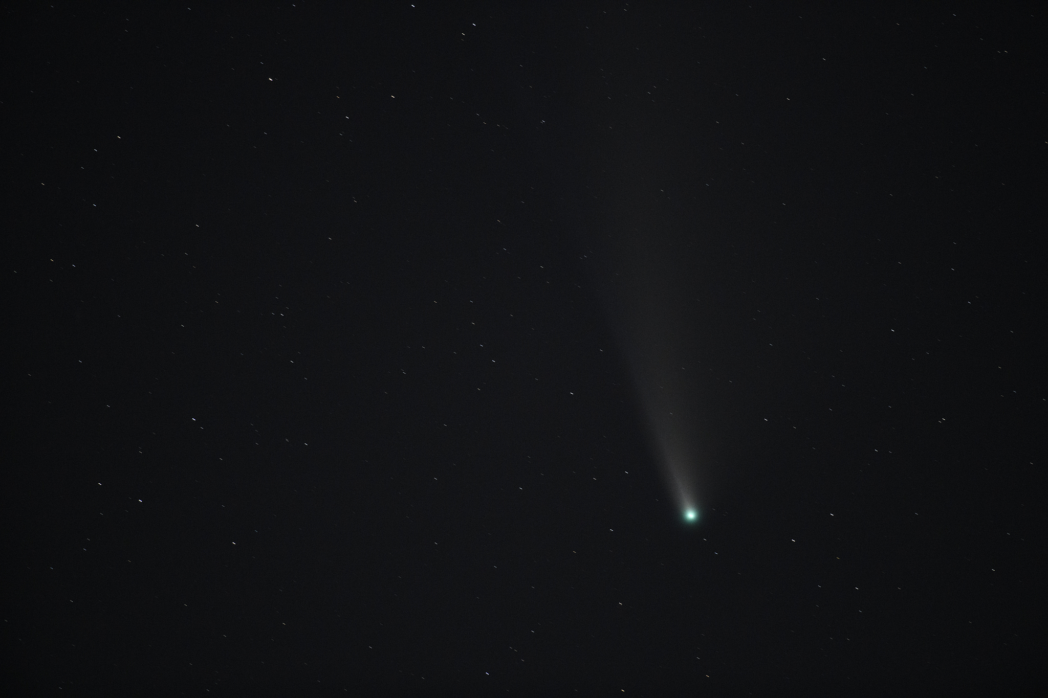 comet in the dark night sky with stars in the background