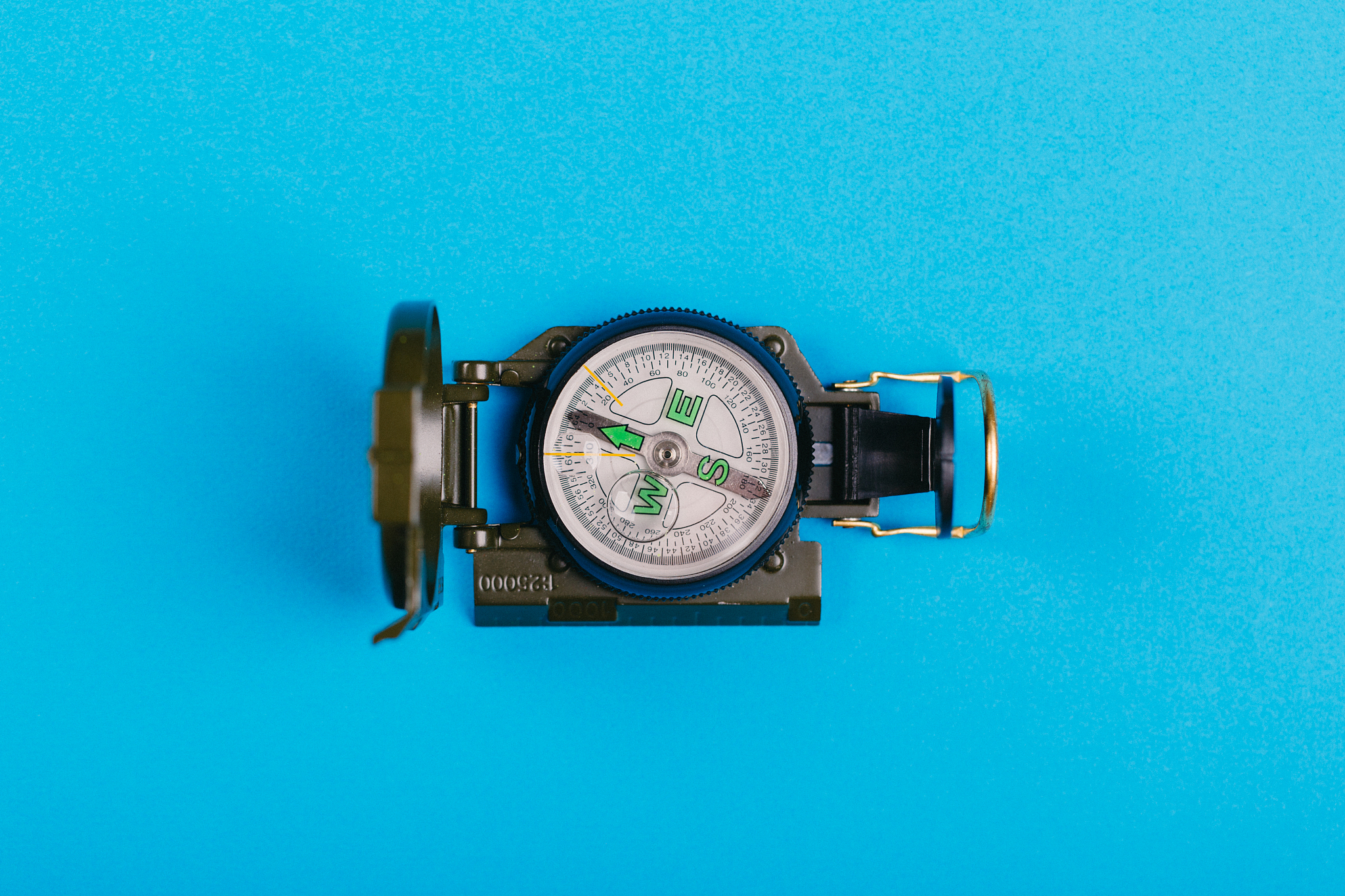 modern nautical metal tourist compass on a blue background. trav