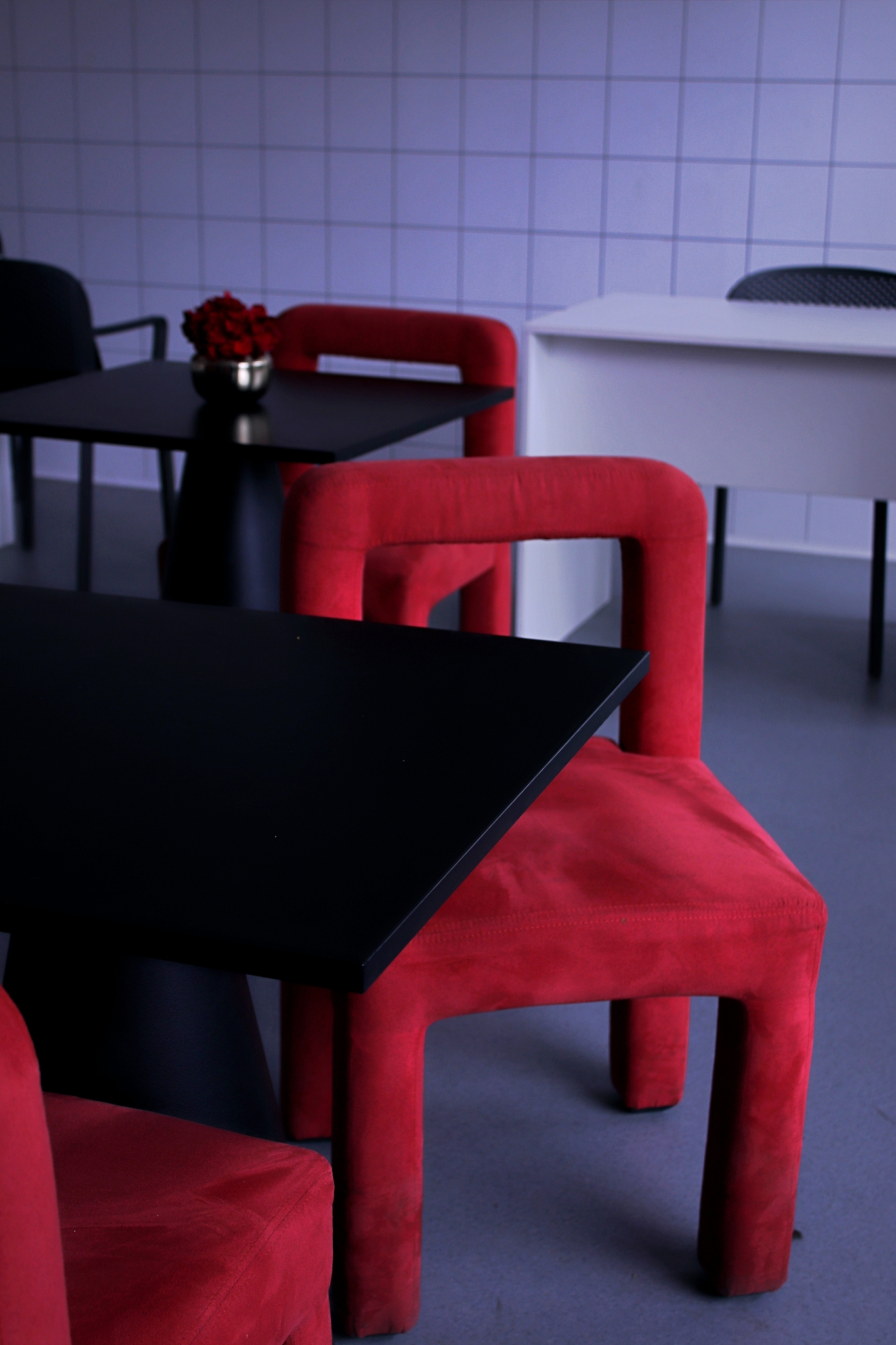 a close up of a red chair near a black table