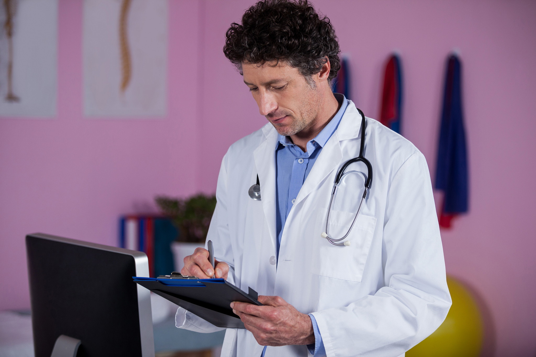 physiotherapist writing on clipboard