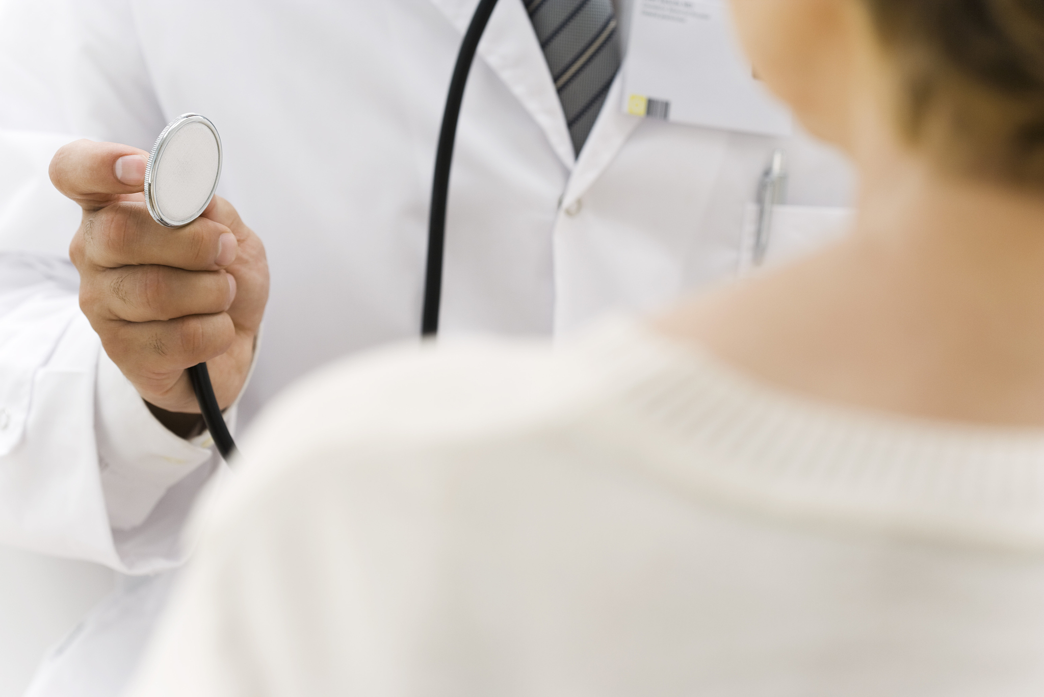 doctor preparing to examine patient using stethoscope