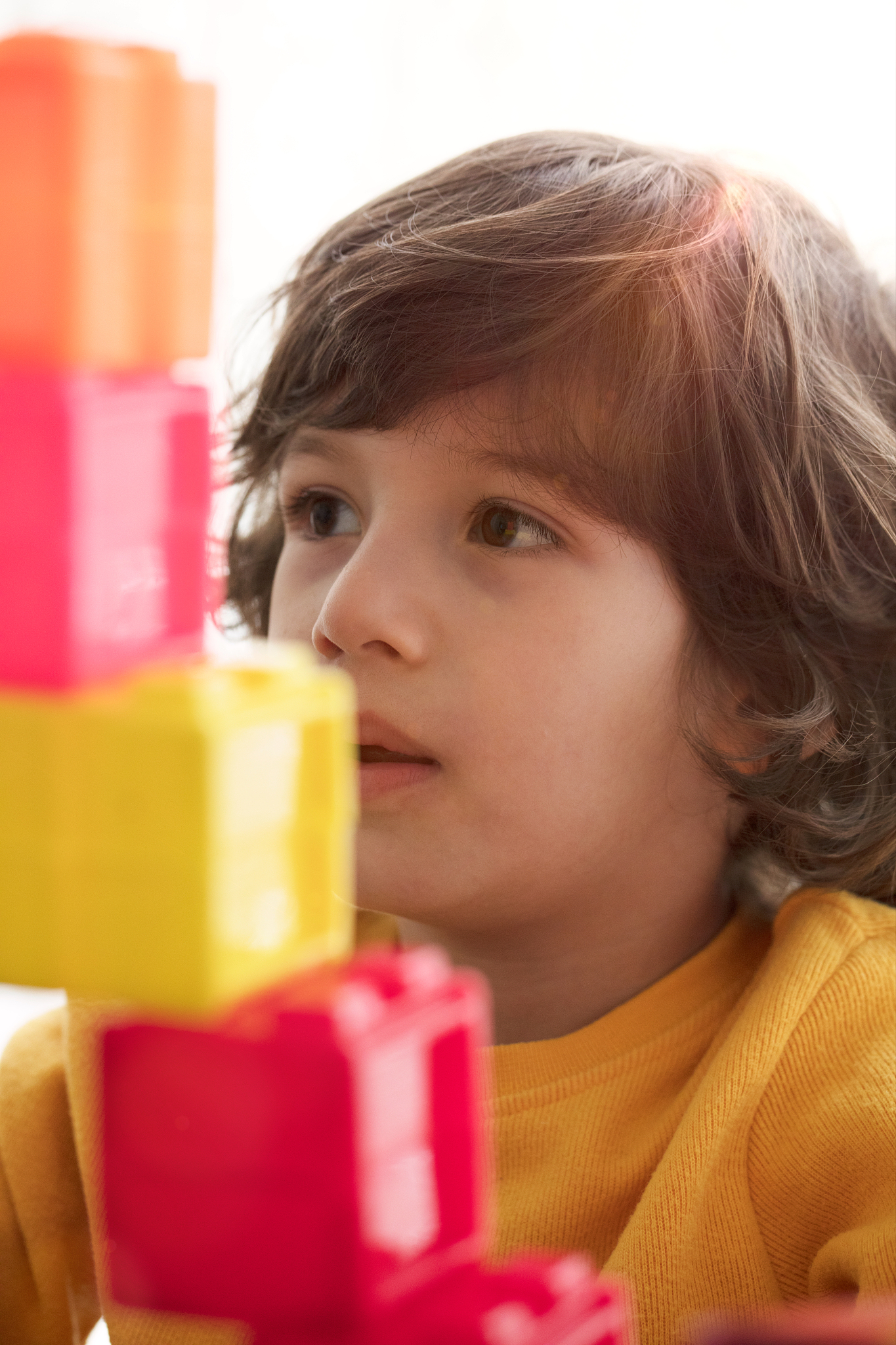 happy child playing with preschoolers building blocks