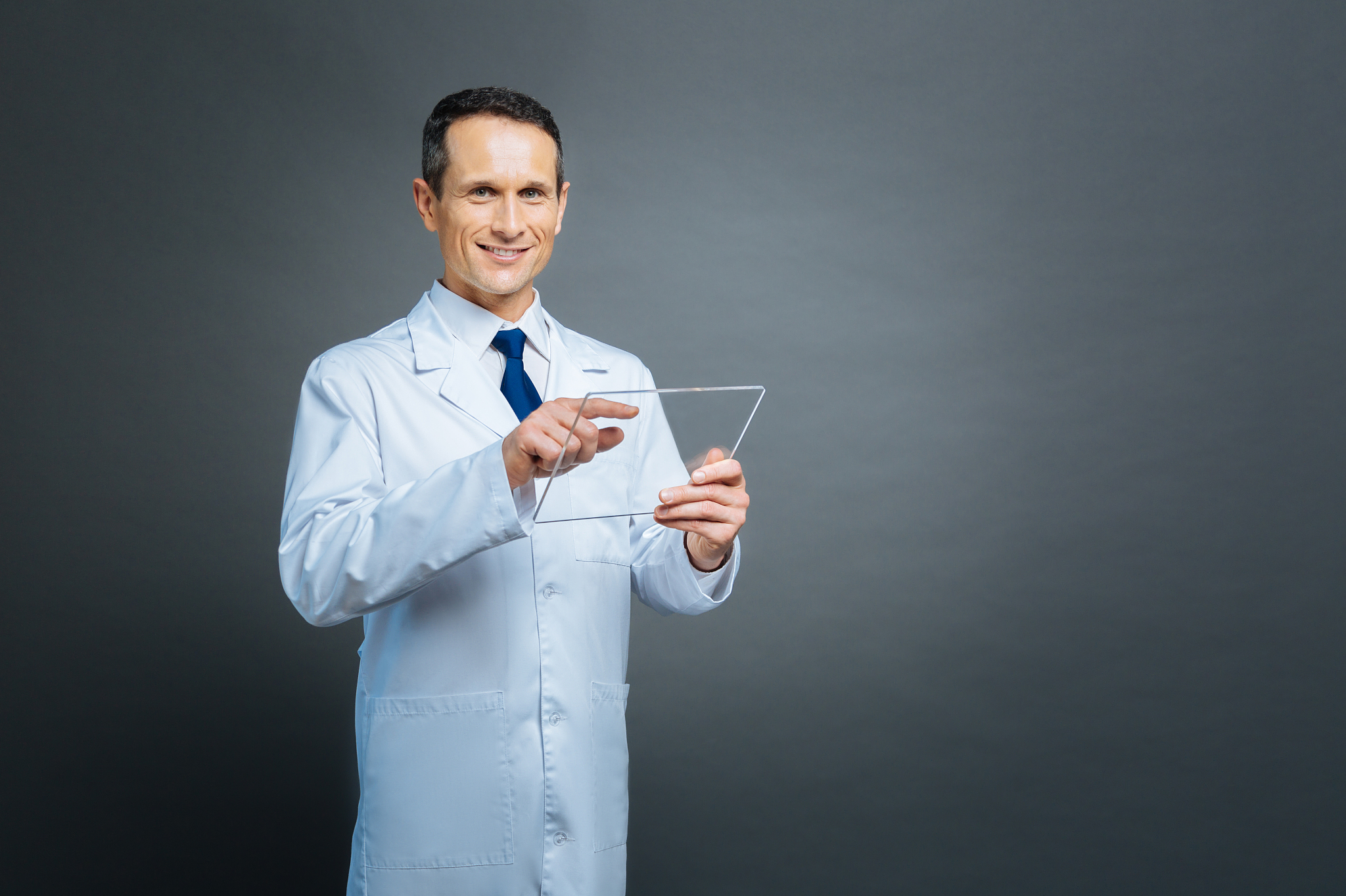 mature scientist posing with transparent gadget