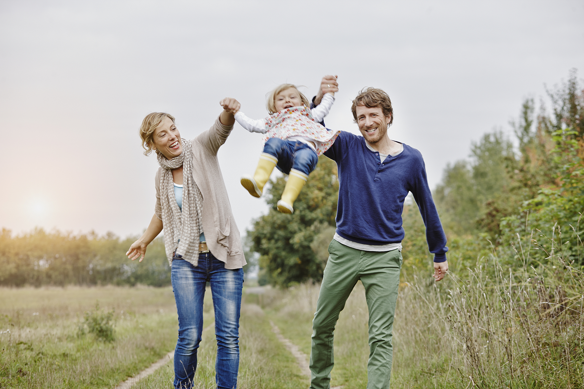 family on a trip lifting up daughter