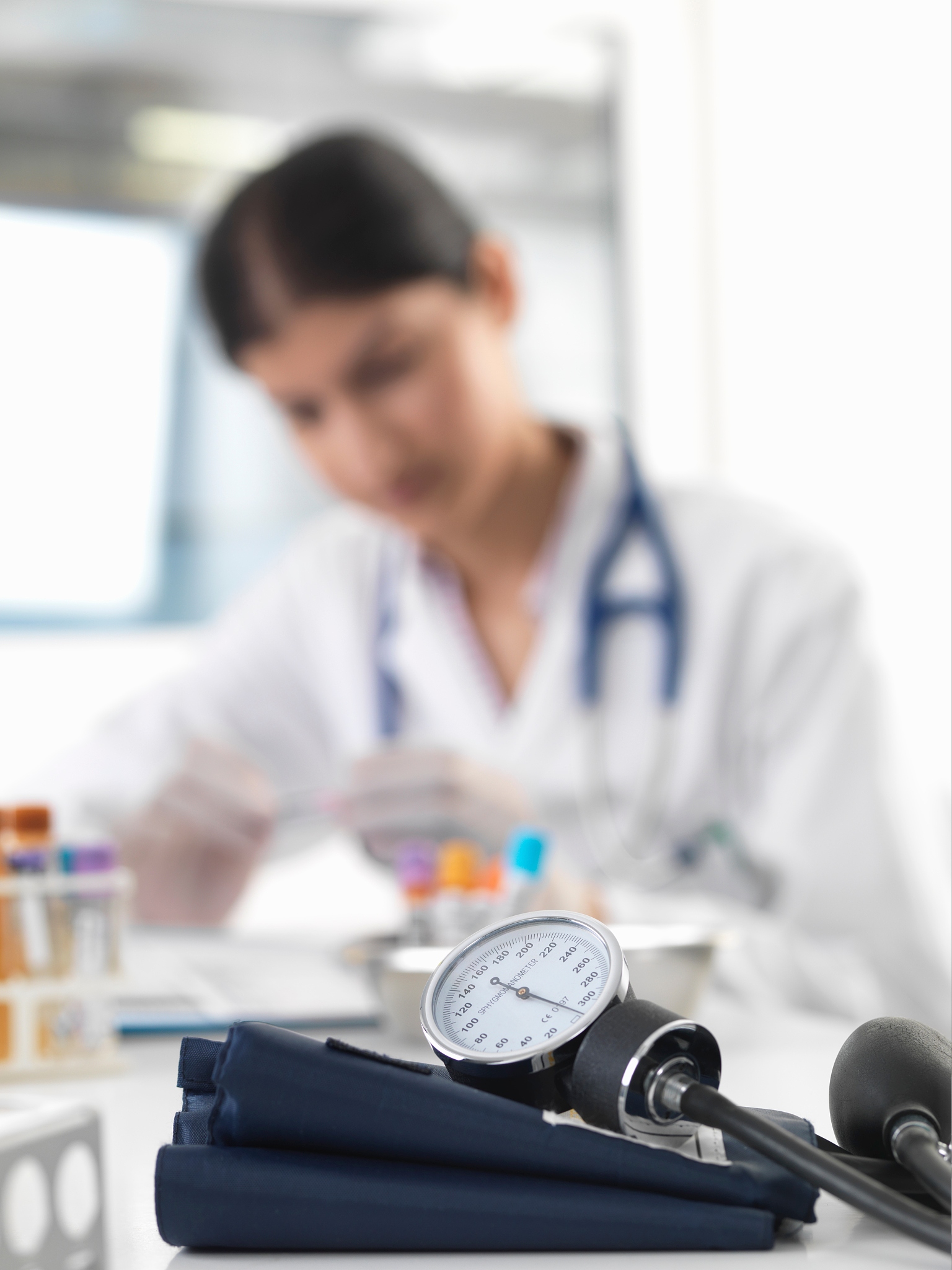 female doctor examining test tube at desk in clinic