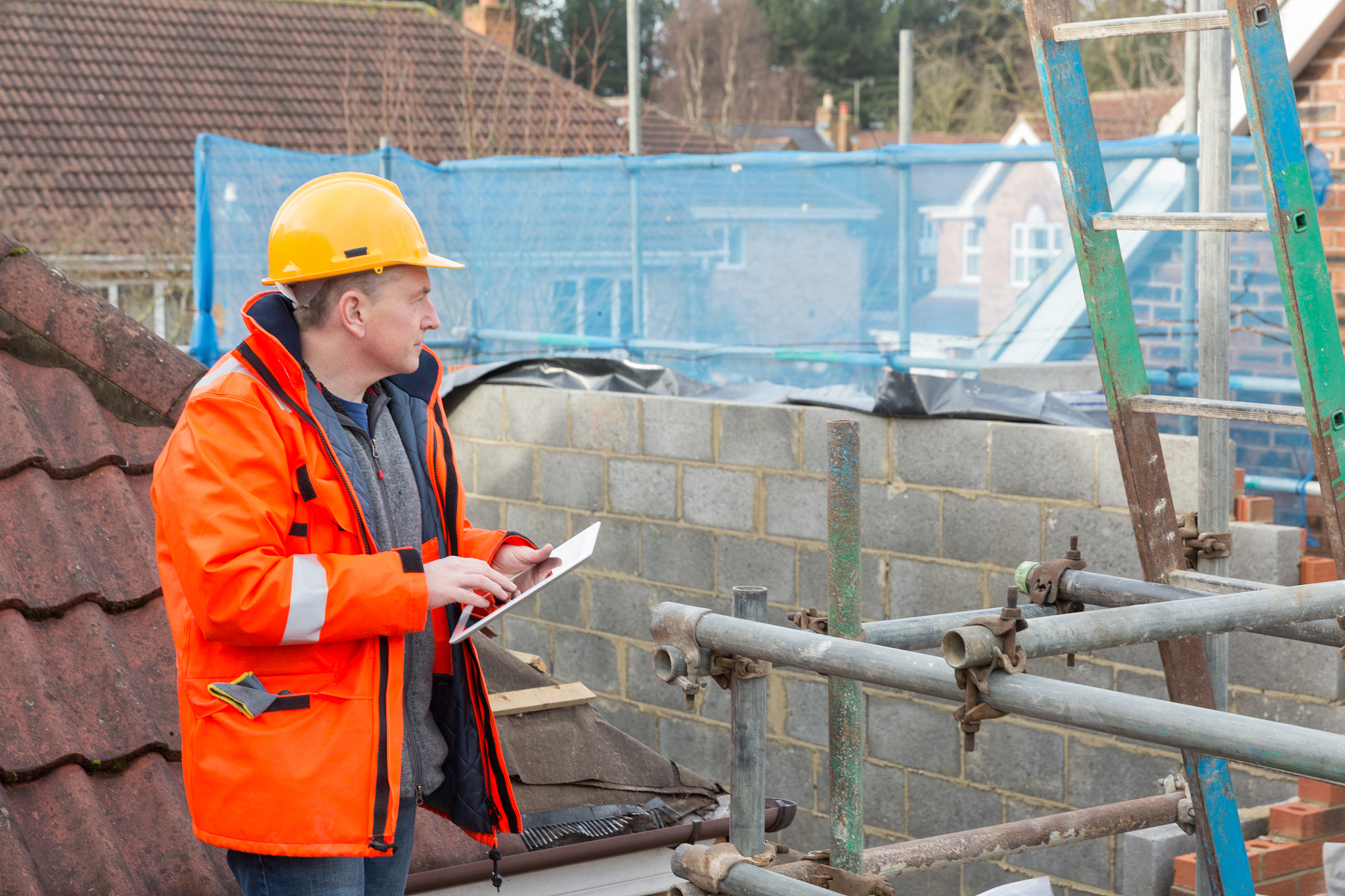male builder surveyor at site with computer tablet