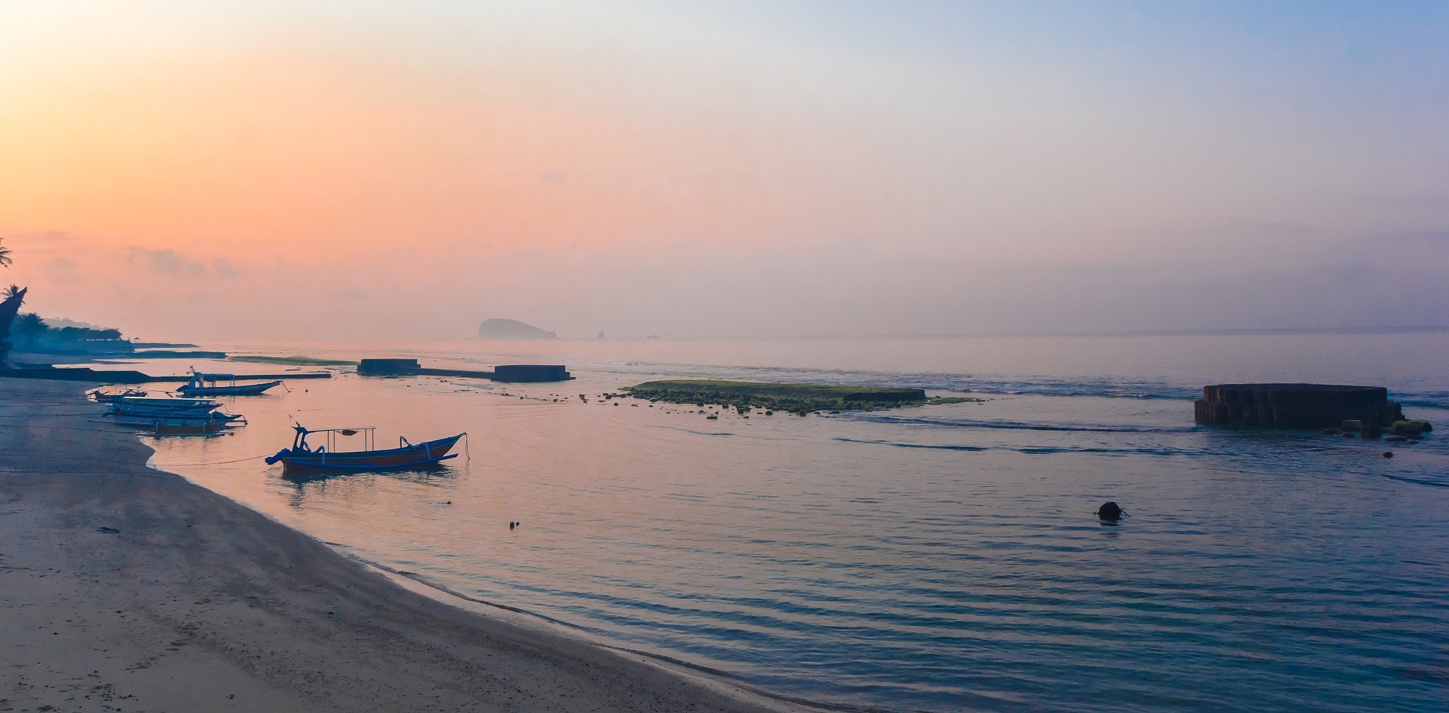 traditional fishing boats in early morning light at the coast of