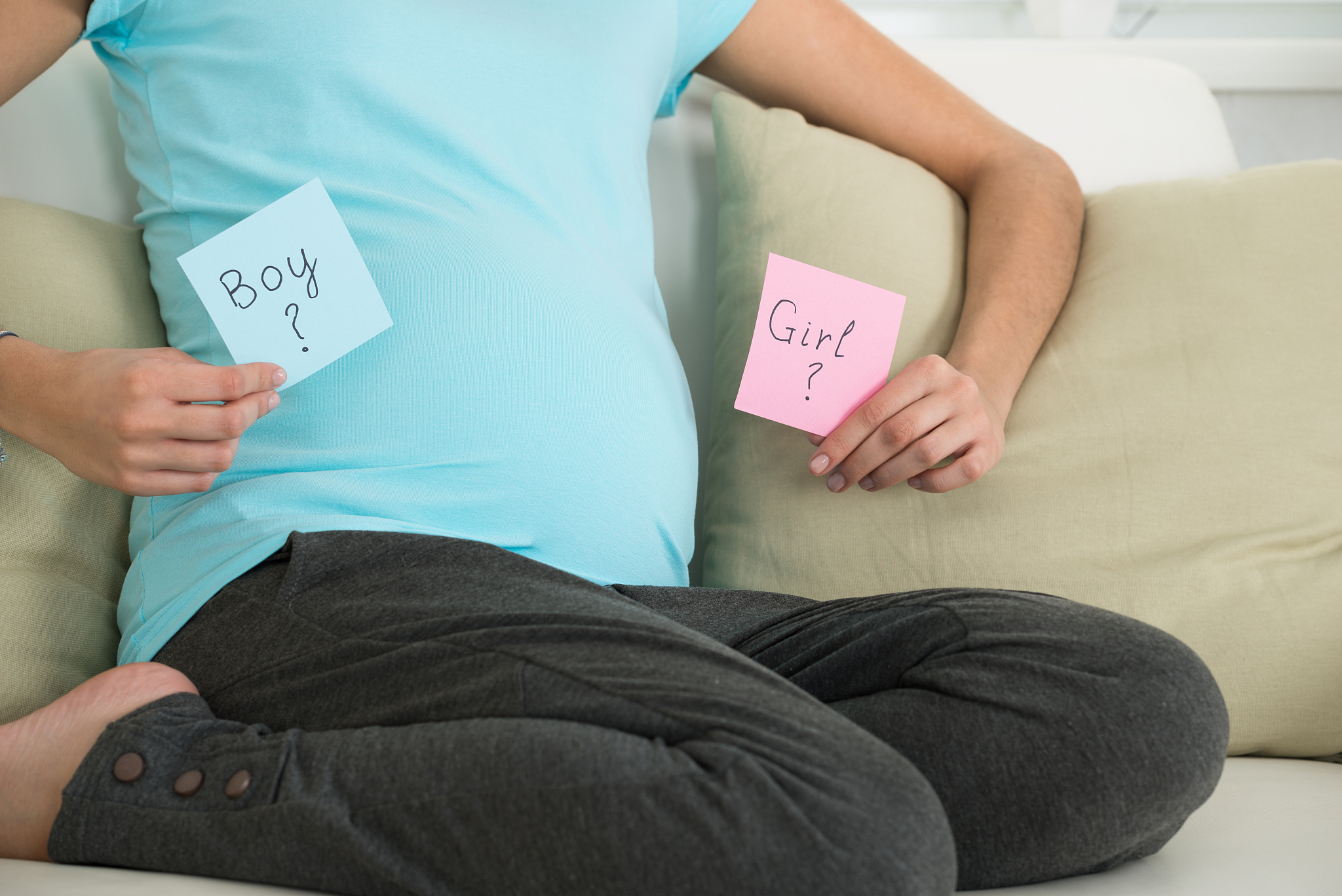 pregnant woman holding boy and girl notes