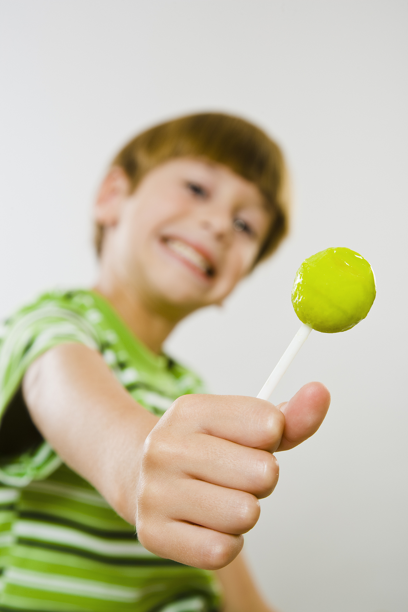 young boy enjoying green lollipop