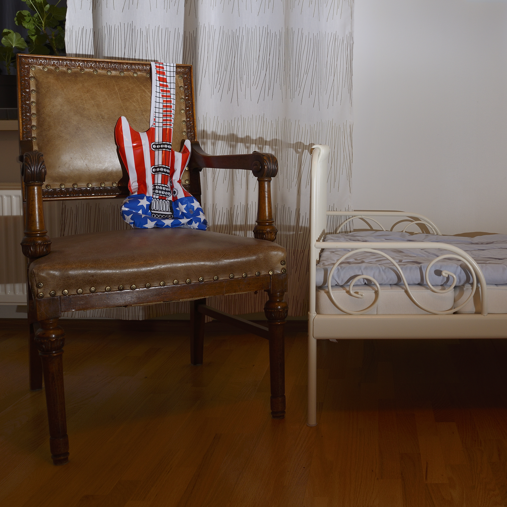 inflatable toy guitar on a leather old armchair