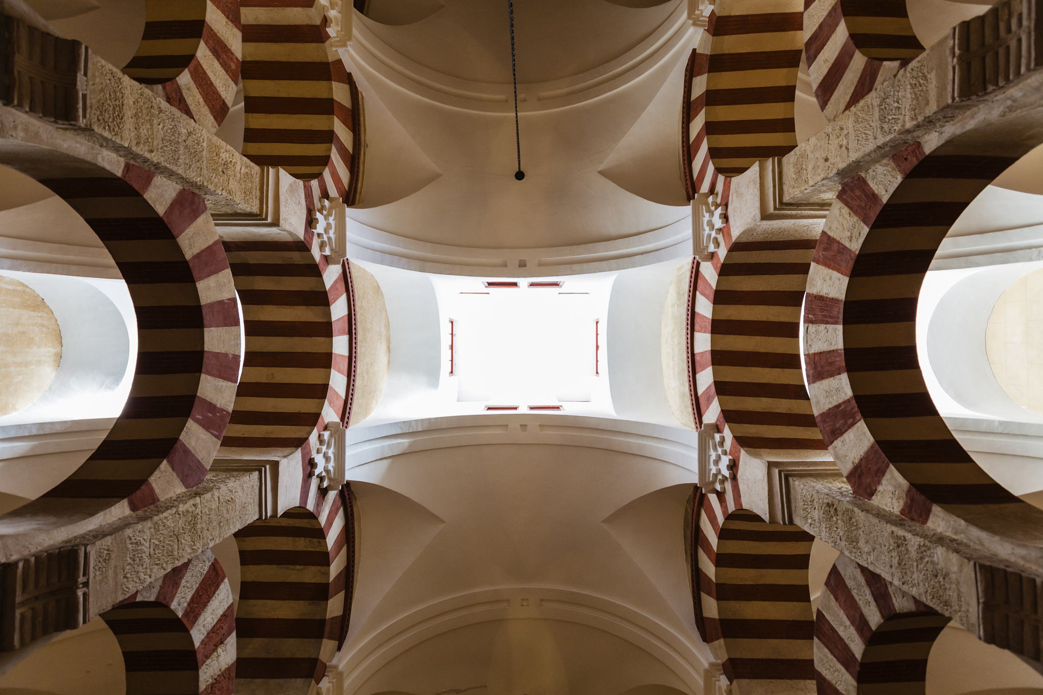 low angle view of ornate arches and skylights in mosque, cordoba