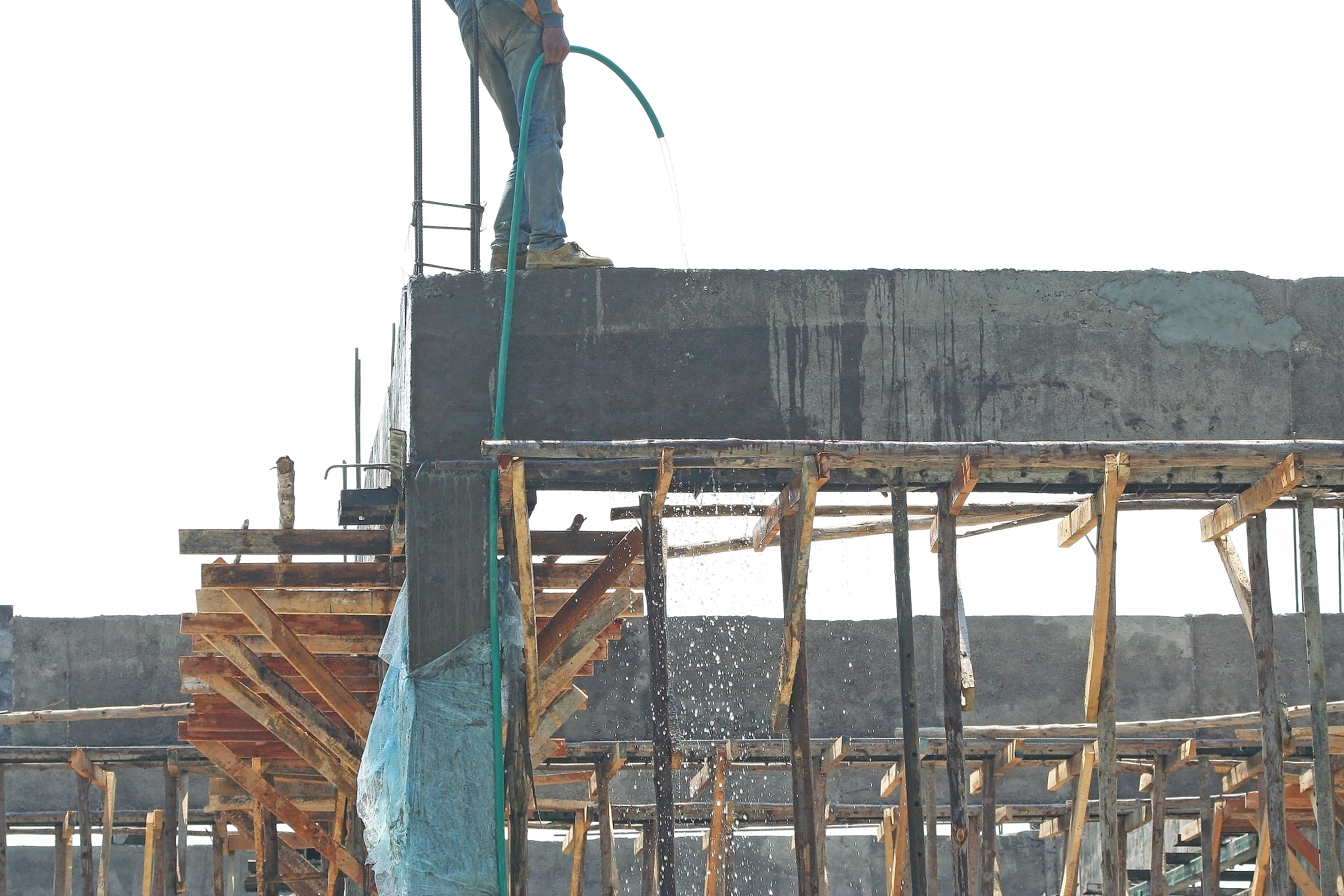 construction site ,worker using hose watering for cleaning the b