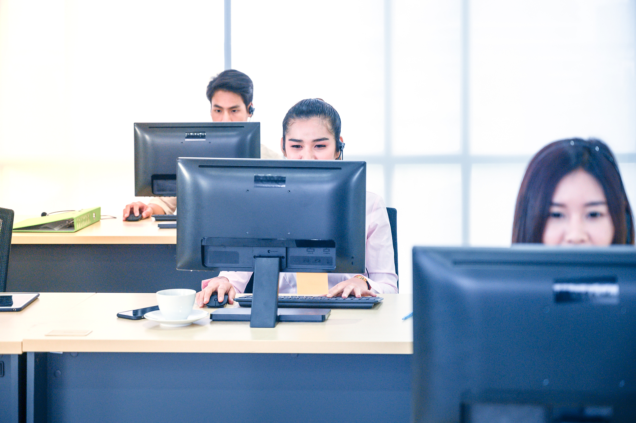 young customer service women agent with headsets and computer wo