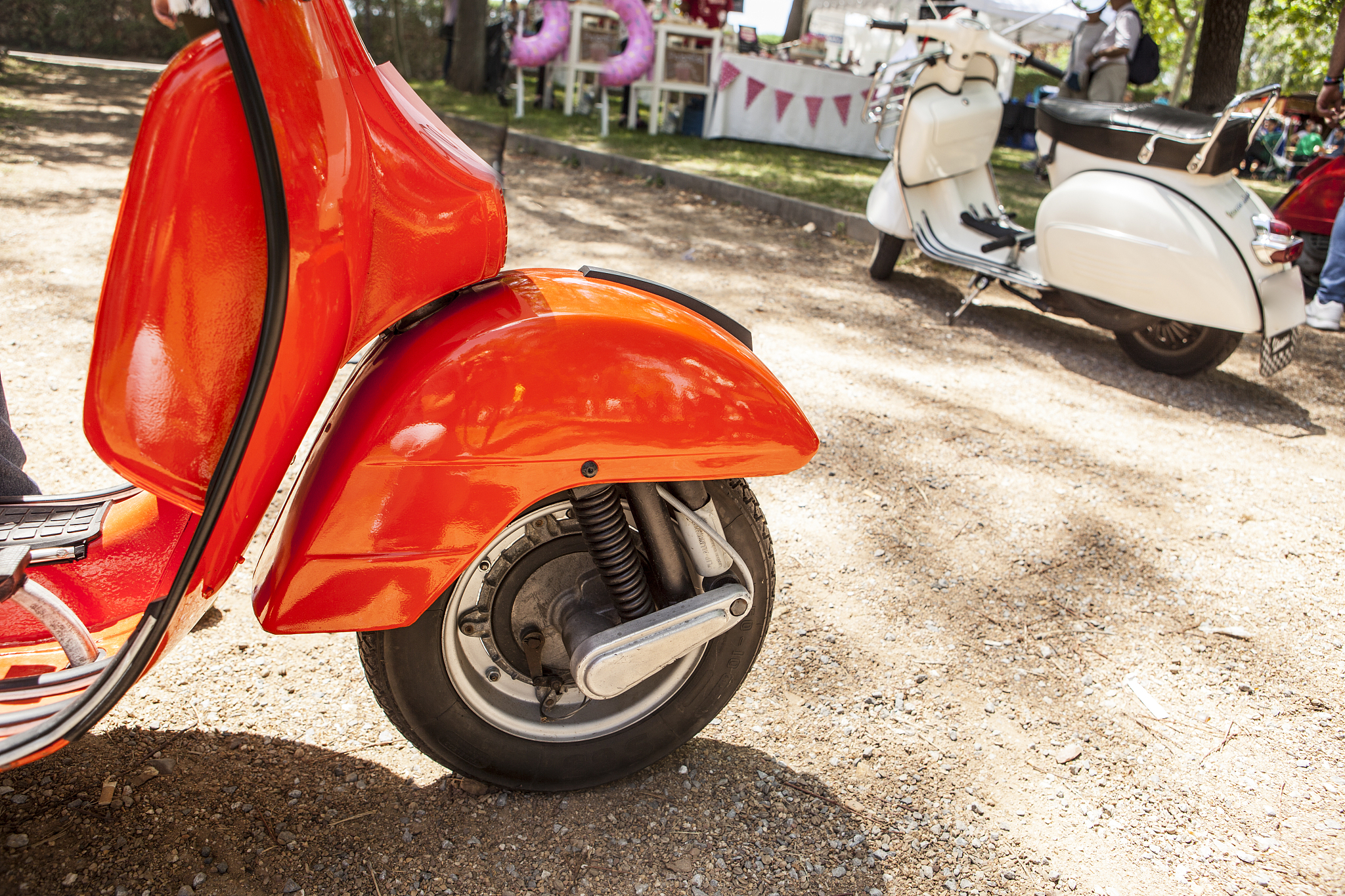 two old style scooter motorbikes parked beside a vintage party