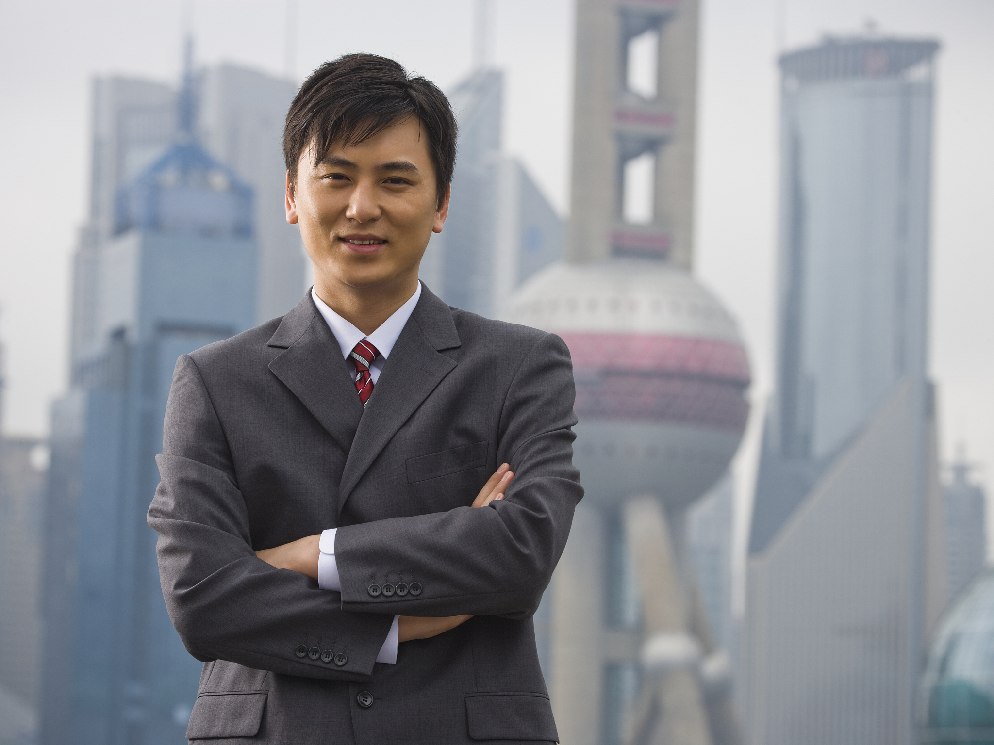 businessman standing with arms crossed outdoors