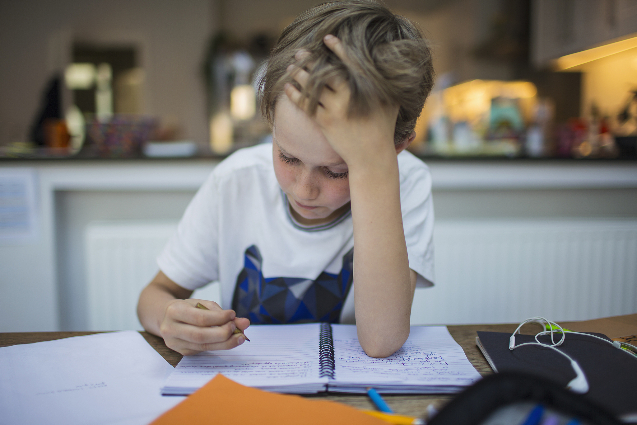 focused boy doing homework at table