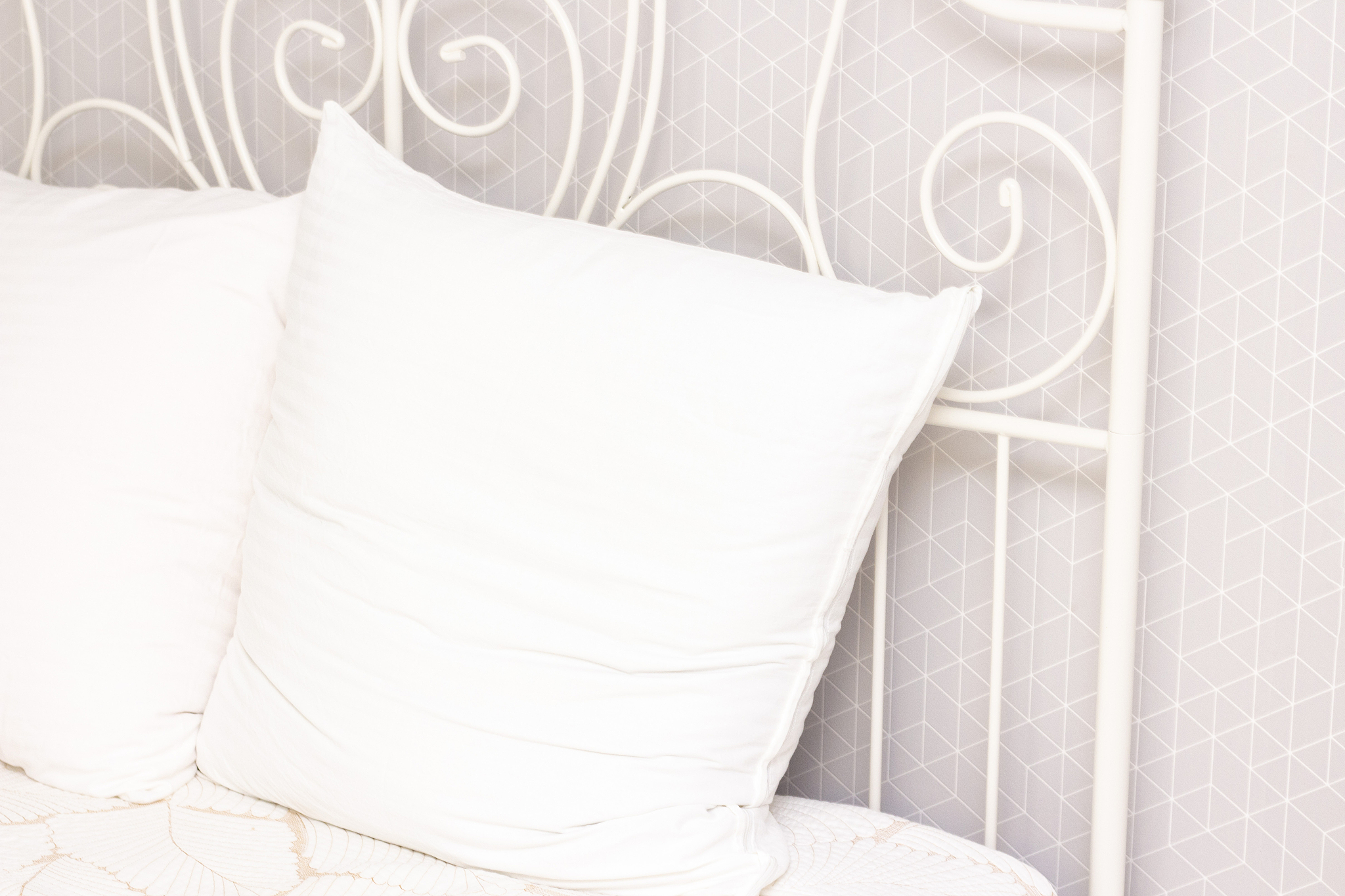 white soft pillow for sleeping at the iron white head of the bed