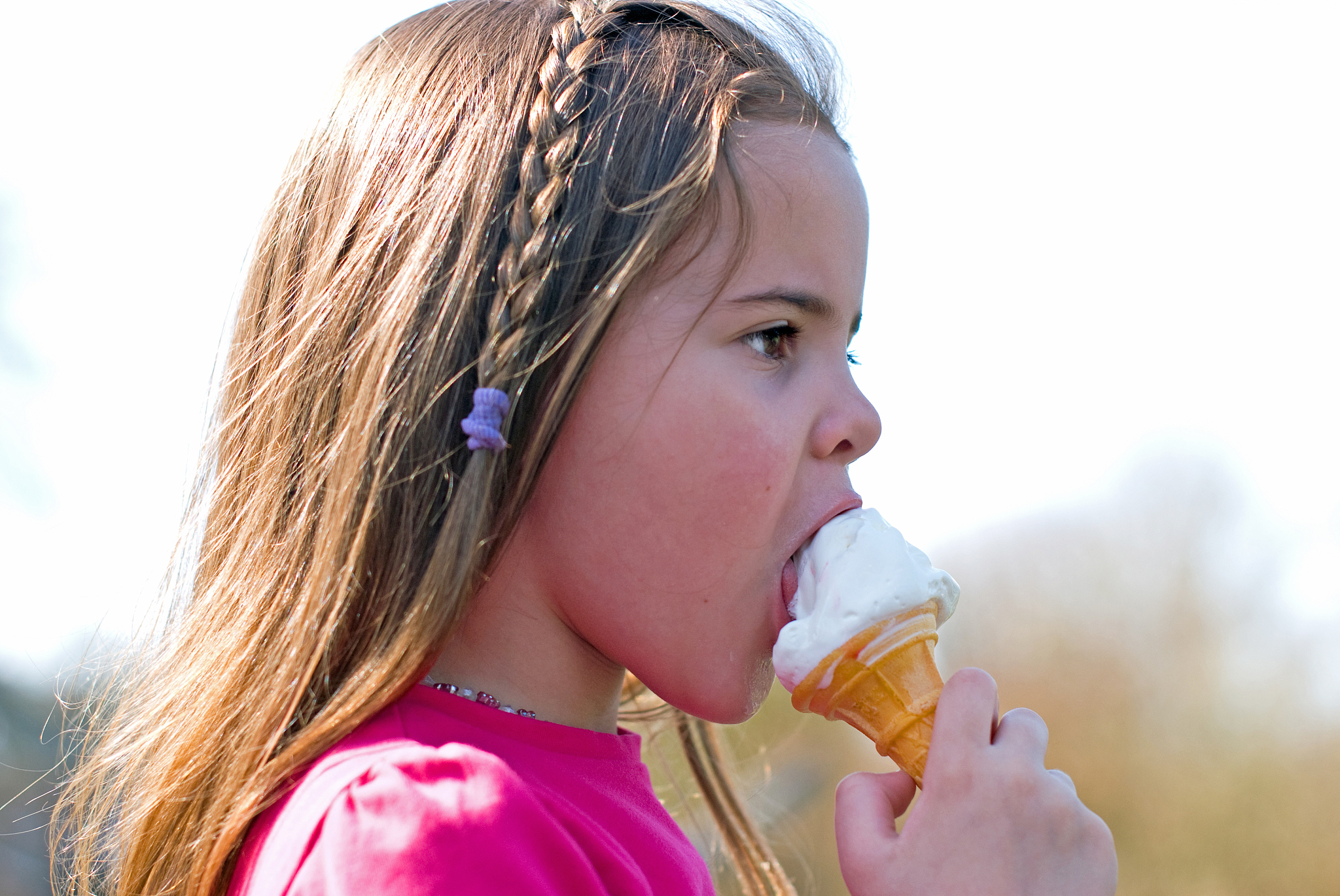 side profile of a young girl eating ice cream