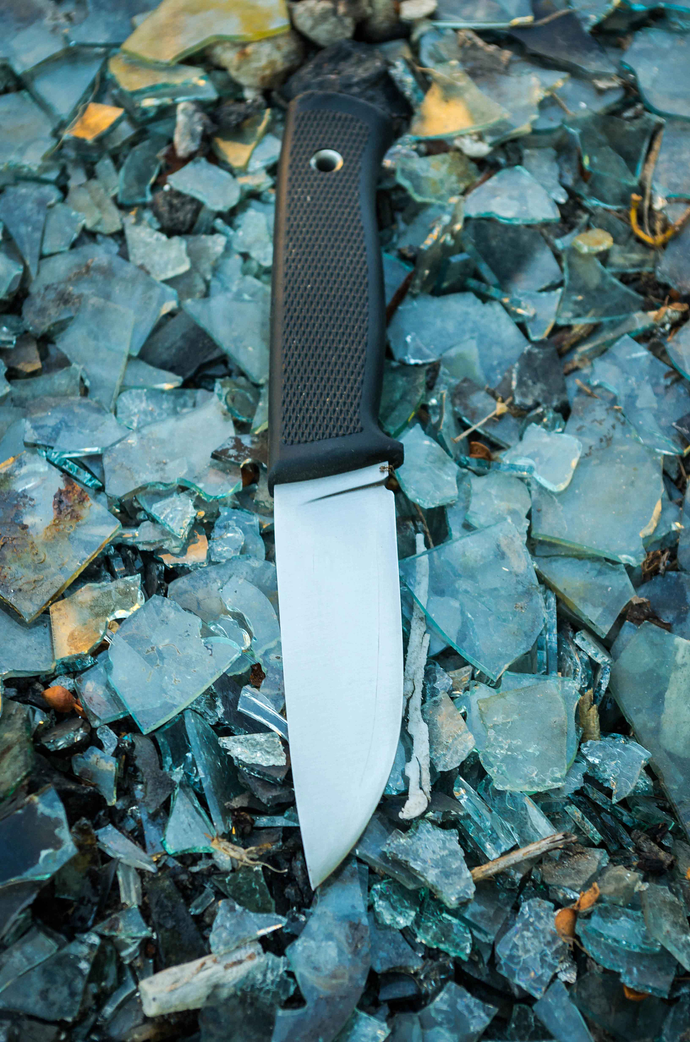 outdoor knife. background colorful. glass. vertical position.