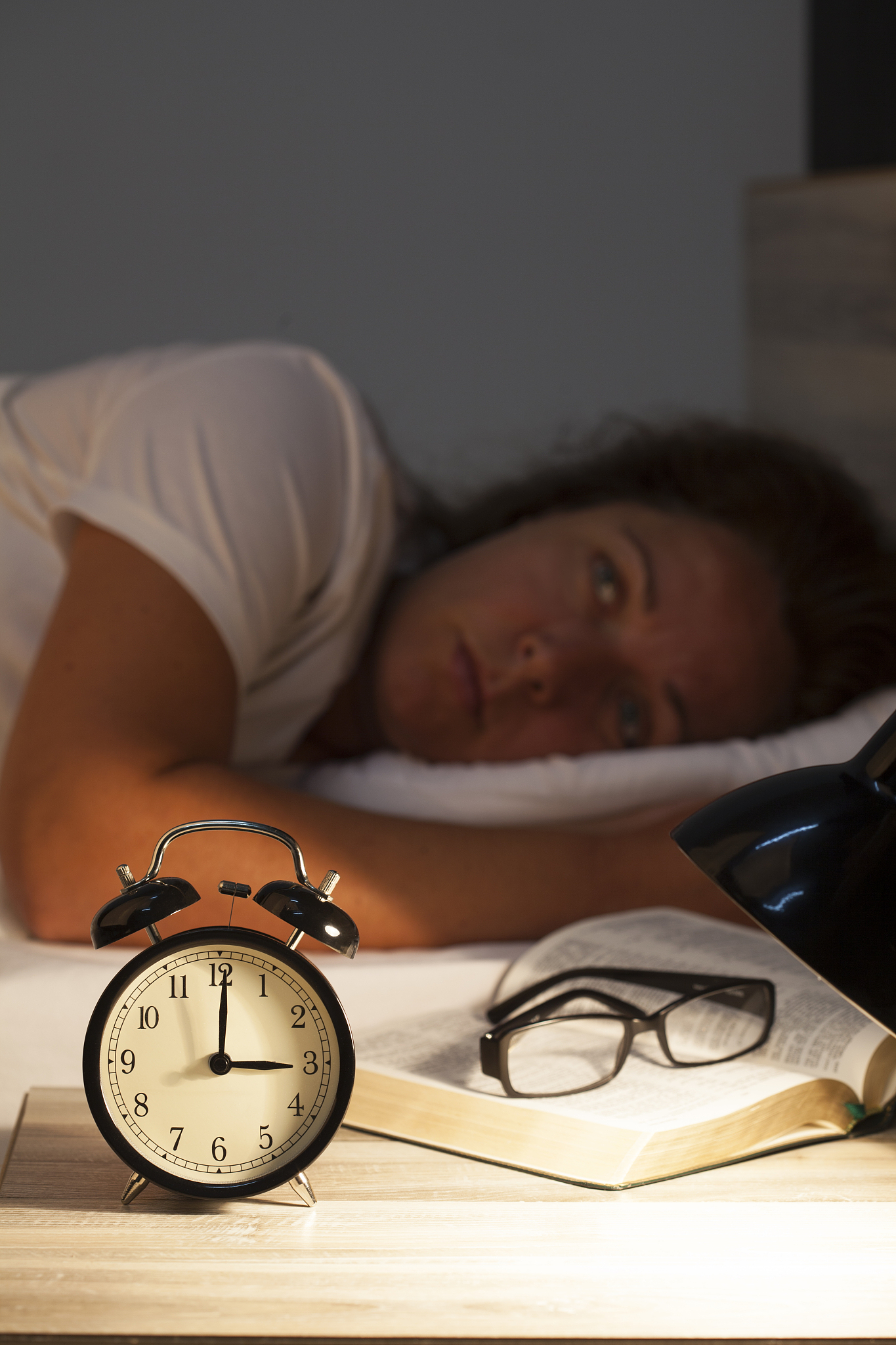 woman lying in bed suffering from insomnia