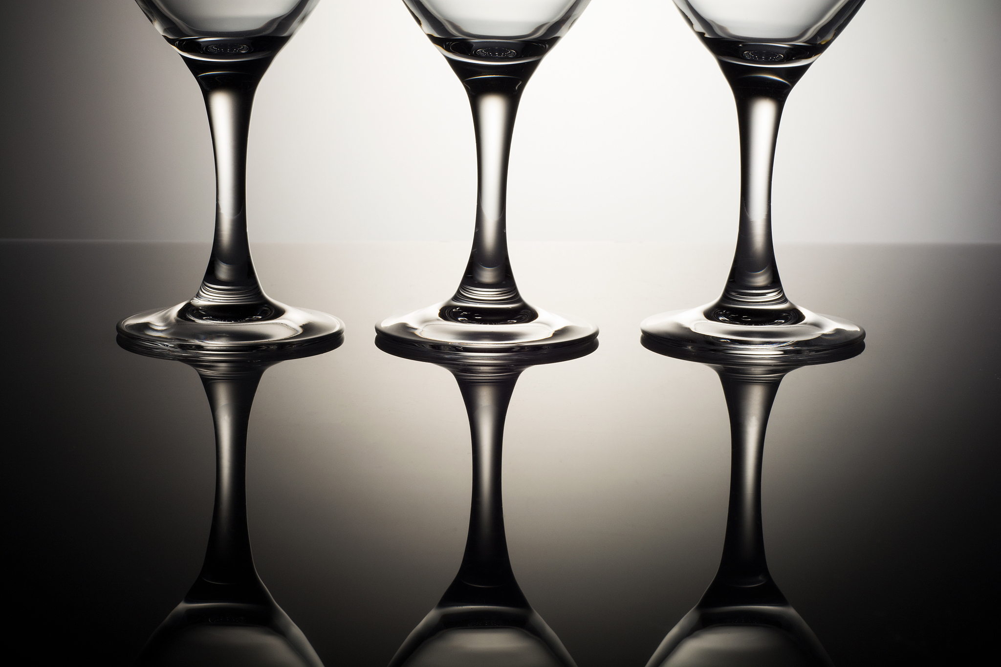 three glasses on a reflective surface