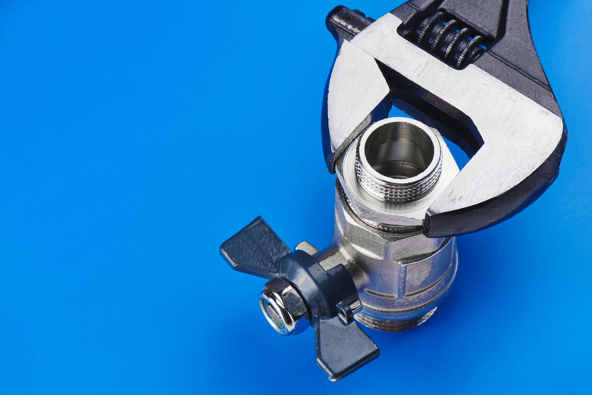 plumbing concept. the adjustable wrench holds the crane on a blu