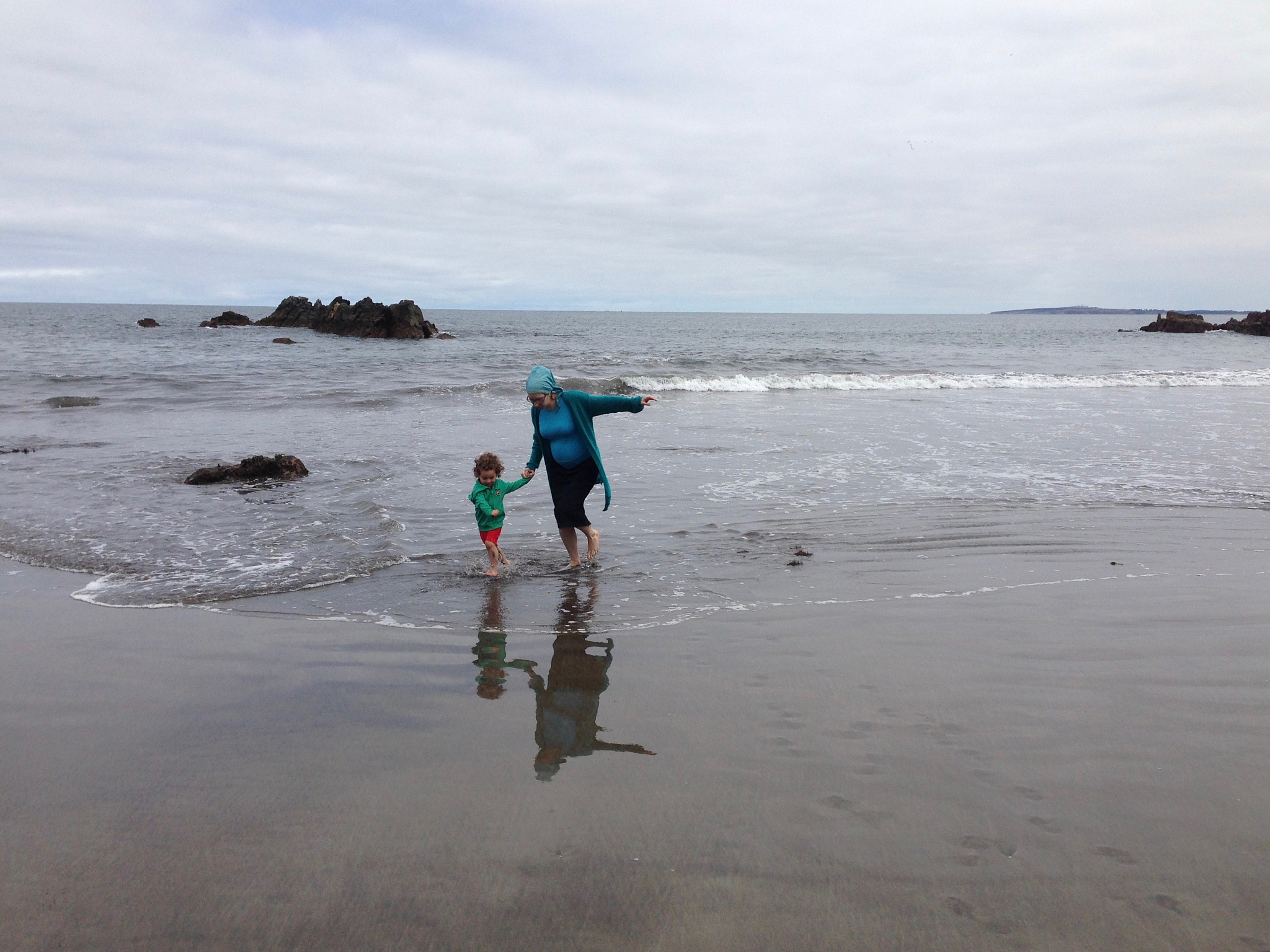 woman with son walking at beach