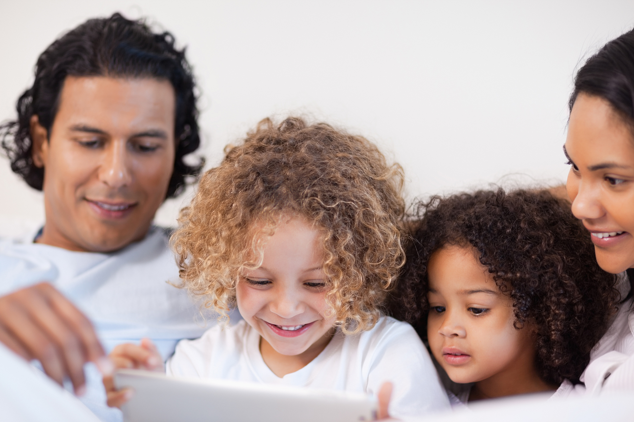 young family having a joyful time in the bed