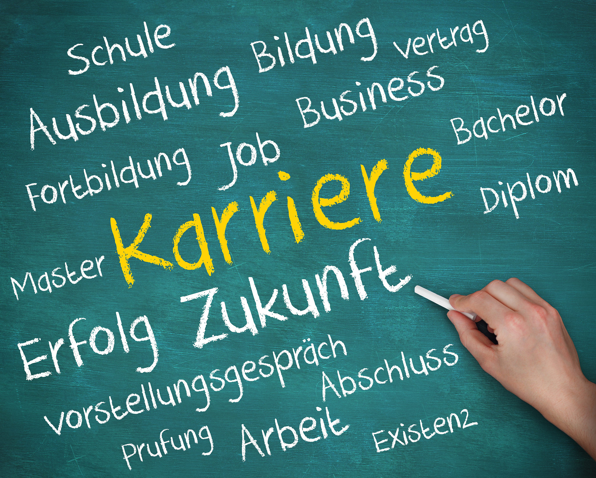 hand holding a chalk and writing words in german