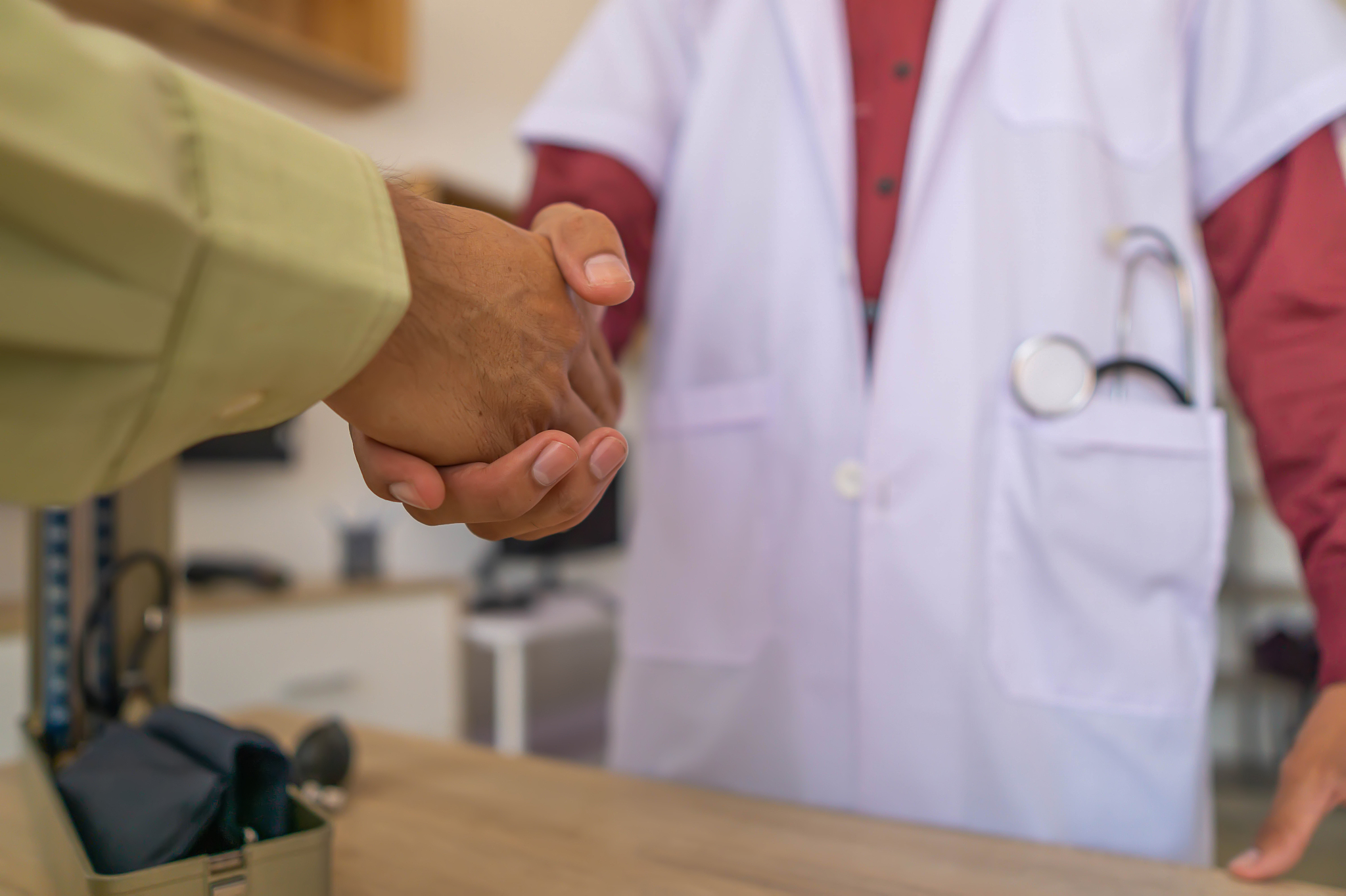 the patient shake hands the doctor to express his gratitude to t