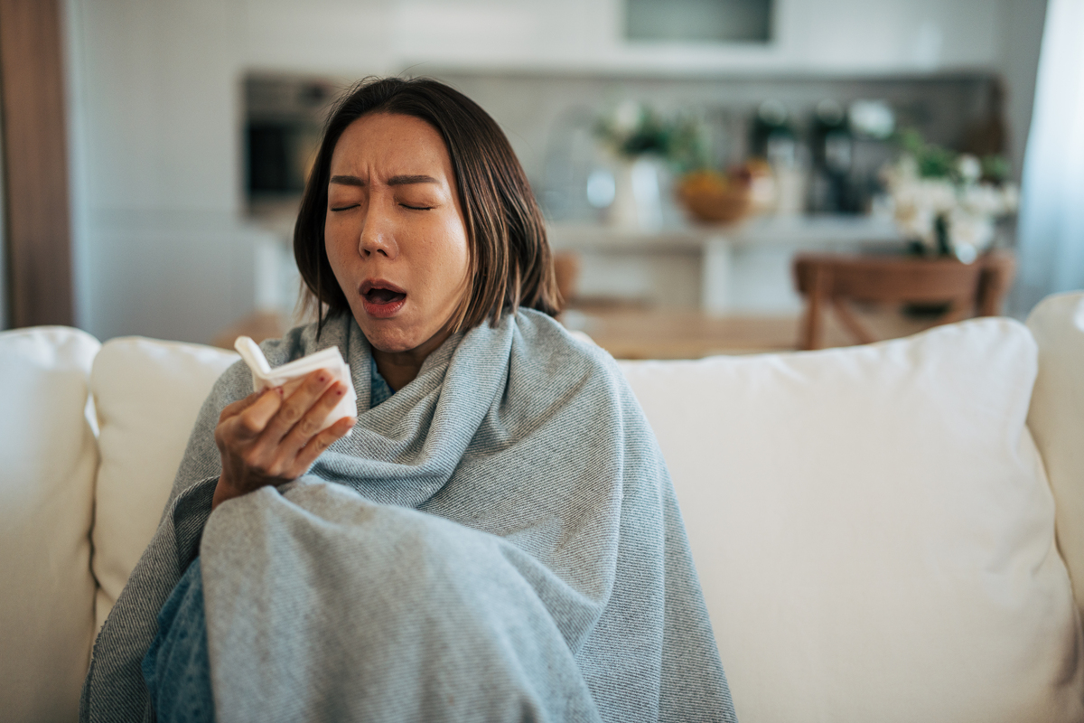 女人在沙发上打喷嚏,<strong>感觉</strong>不适