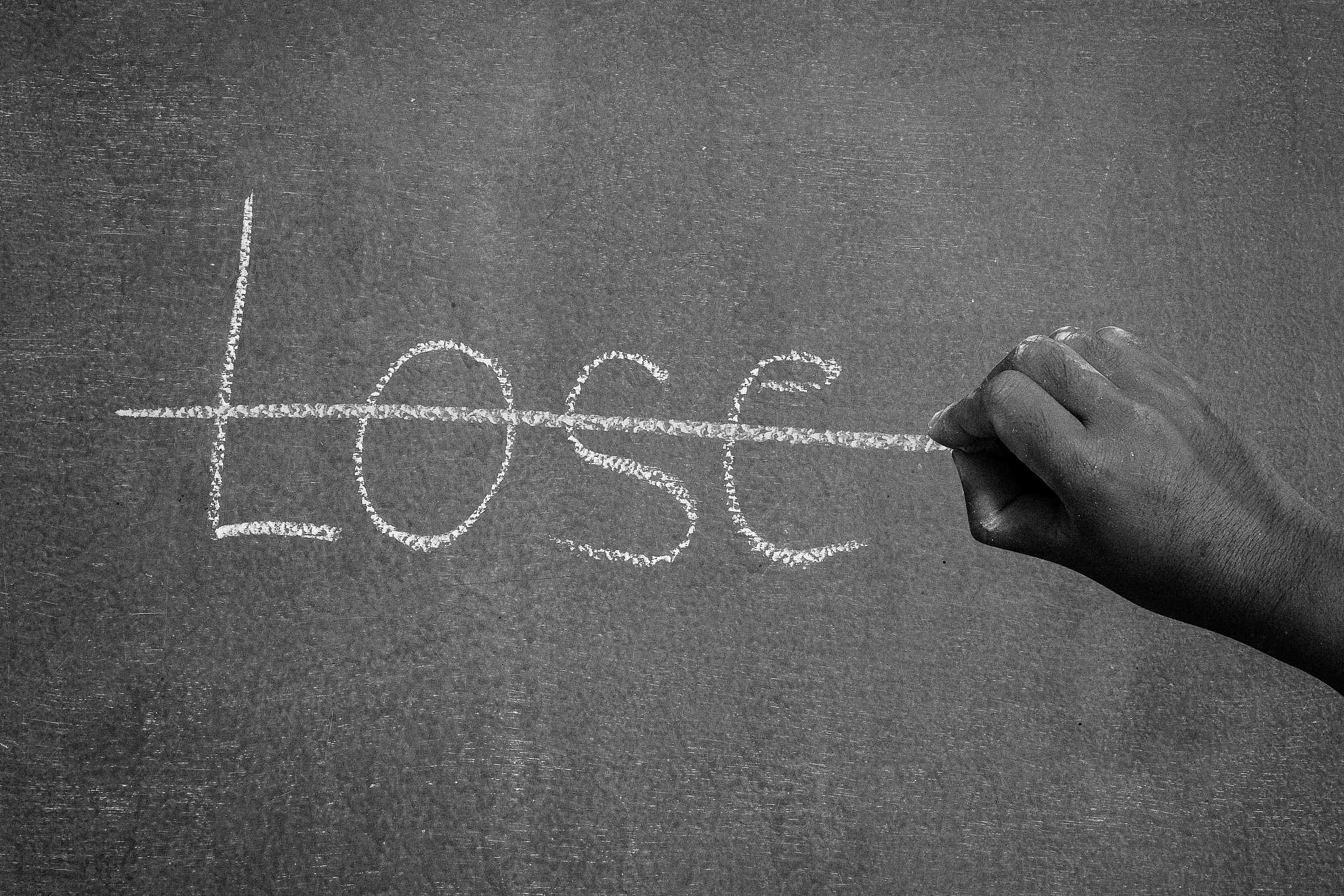 hand crosses the lose on the chalkboard.