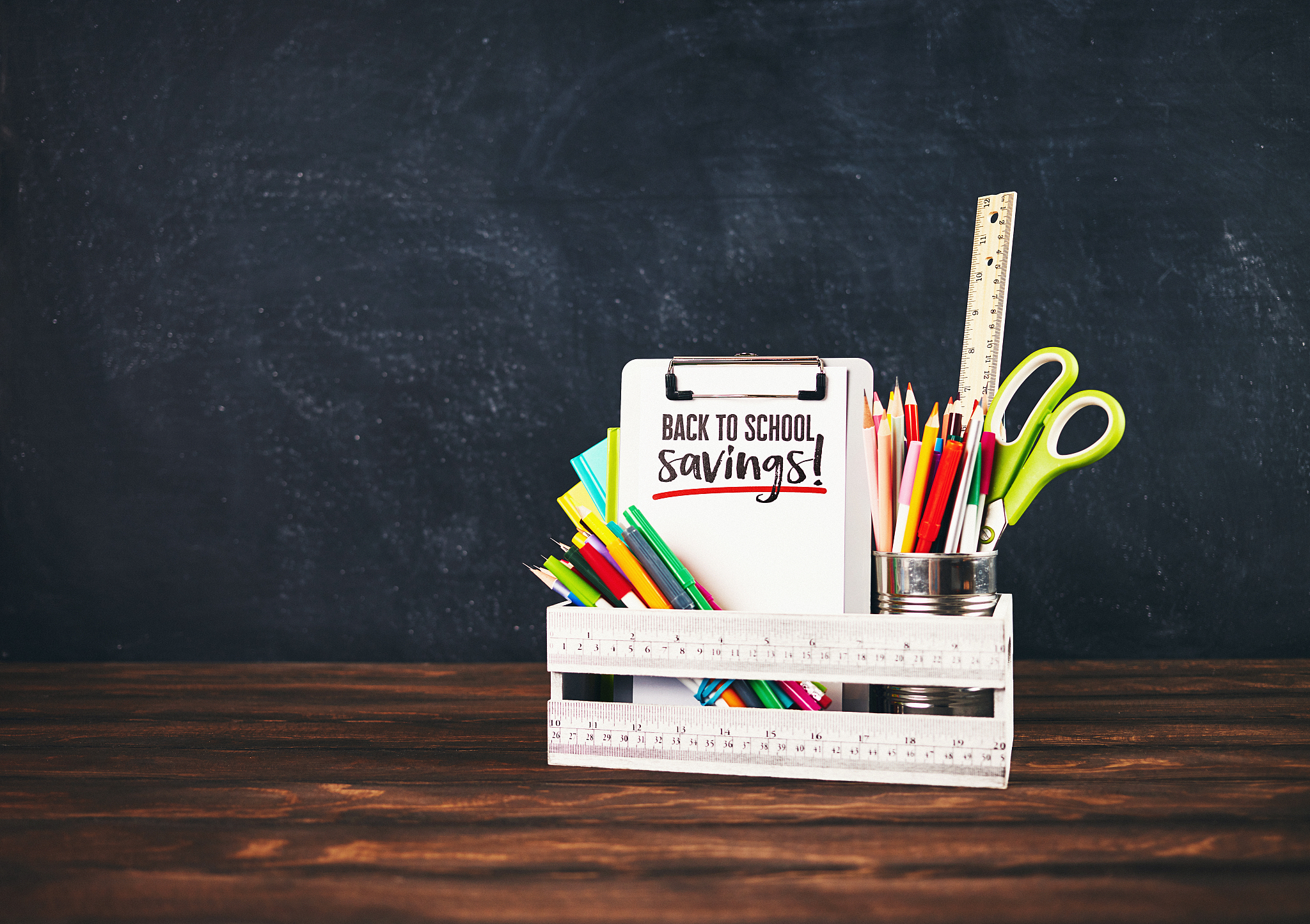 back to school supplies in crate against weathered chalkboard