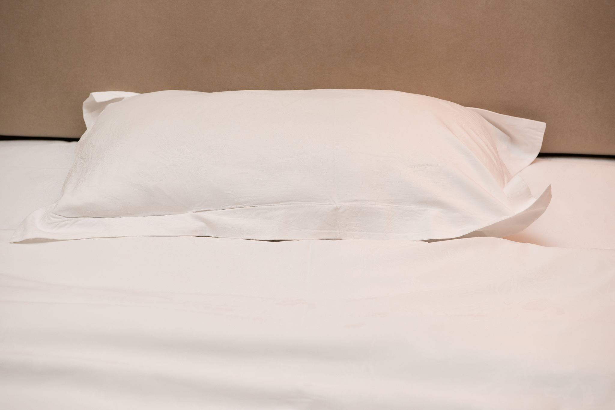 pillow and head board of a bed close up