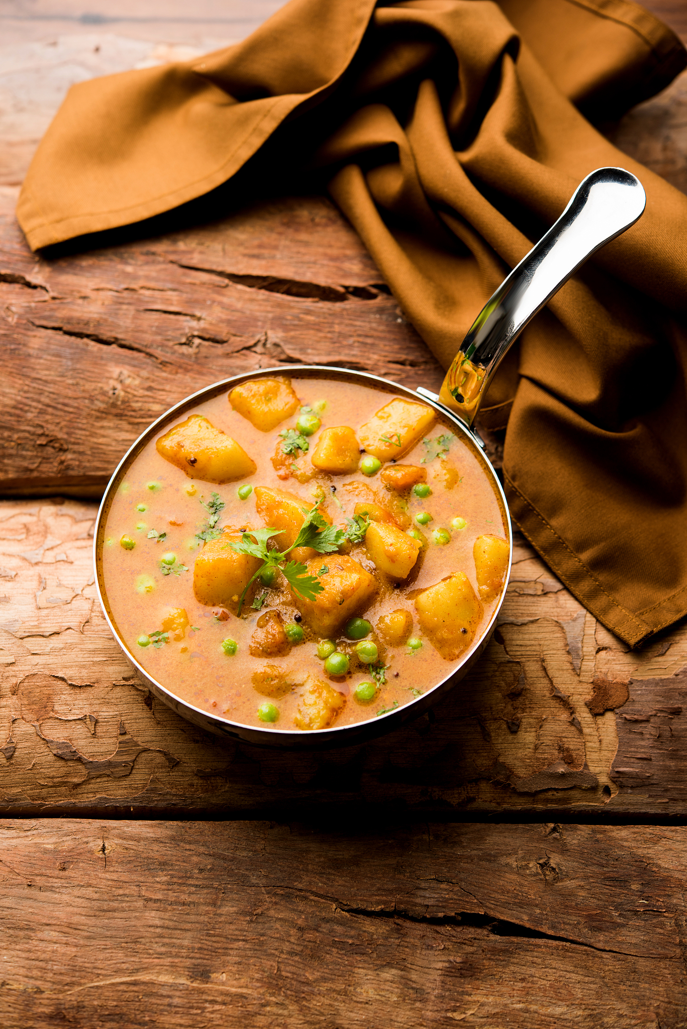 indian aloo mutter curry - potato and peas immersed in an onion 