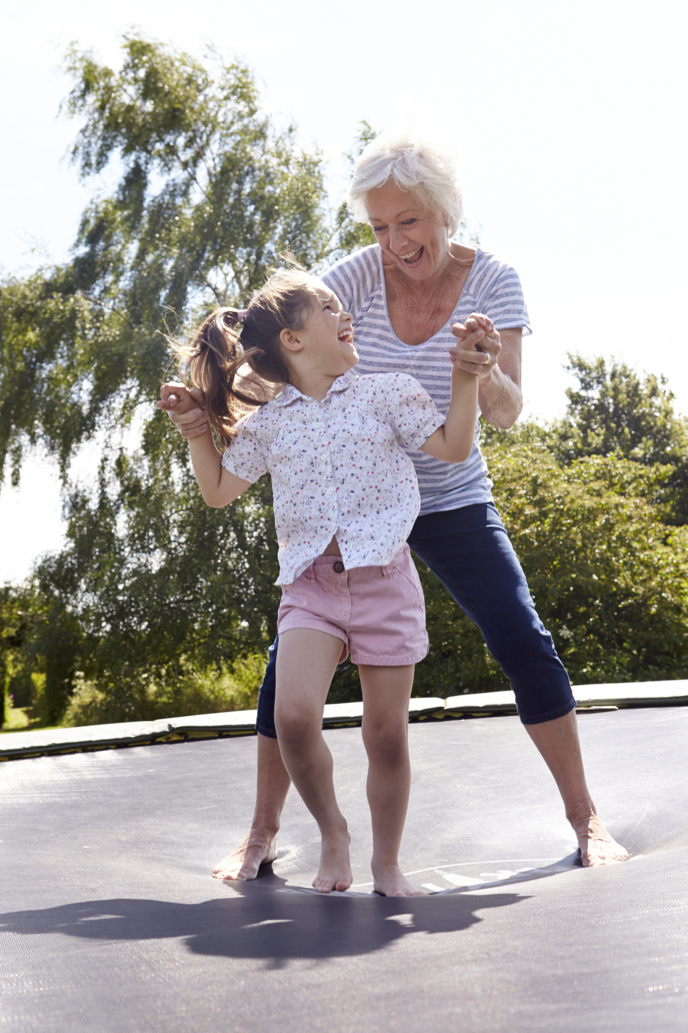 grandmother and granddaughter bouncing on trampoline