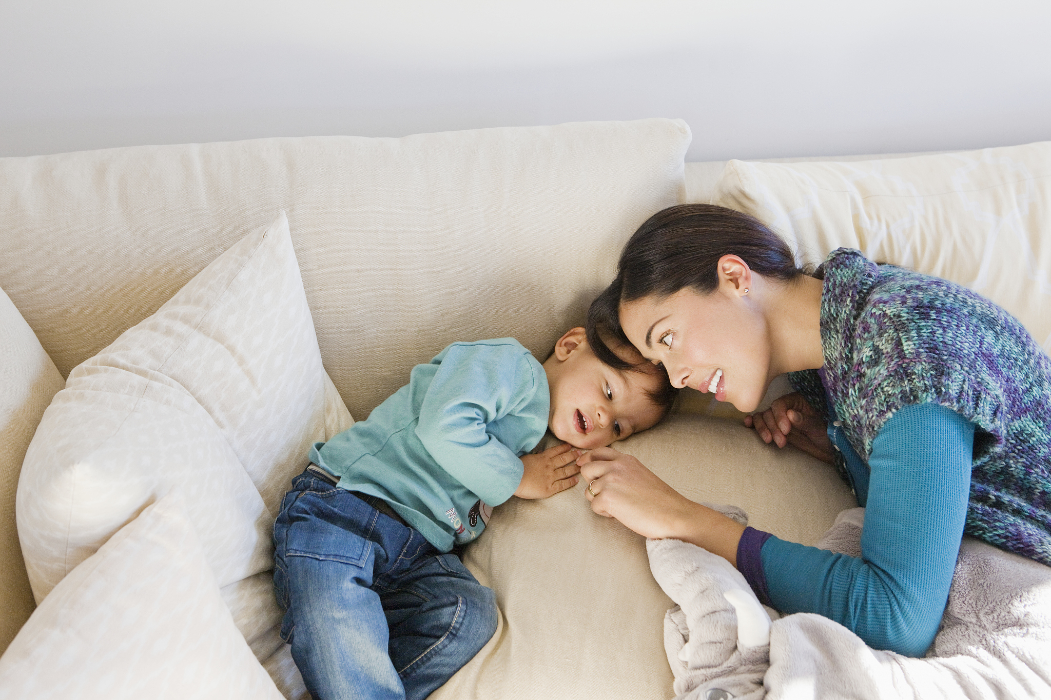 mother playing with son on sofa