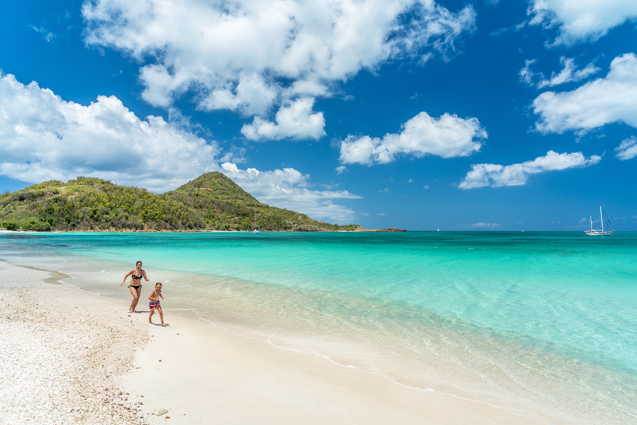mother and son running on beach, caribbean