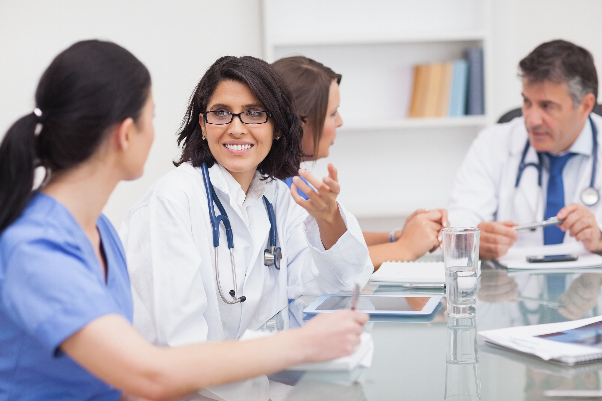 two doctors speaking with two nurses