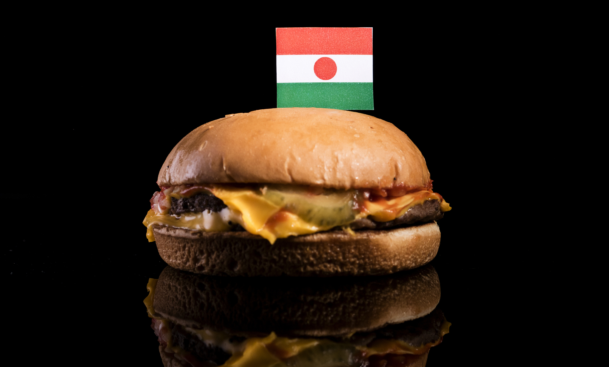 niger flag on top of hamburger isolated on black background