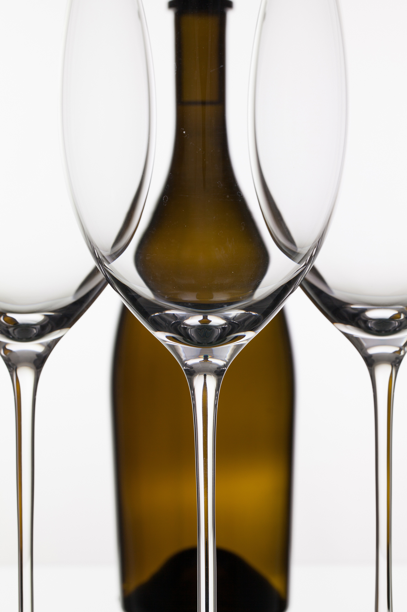three empty glasses of wine and brown bottle