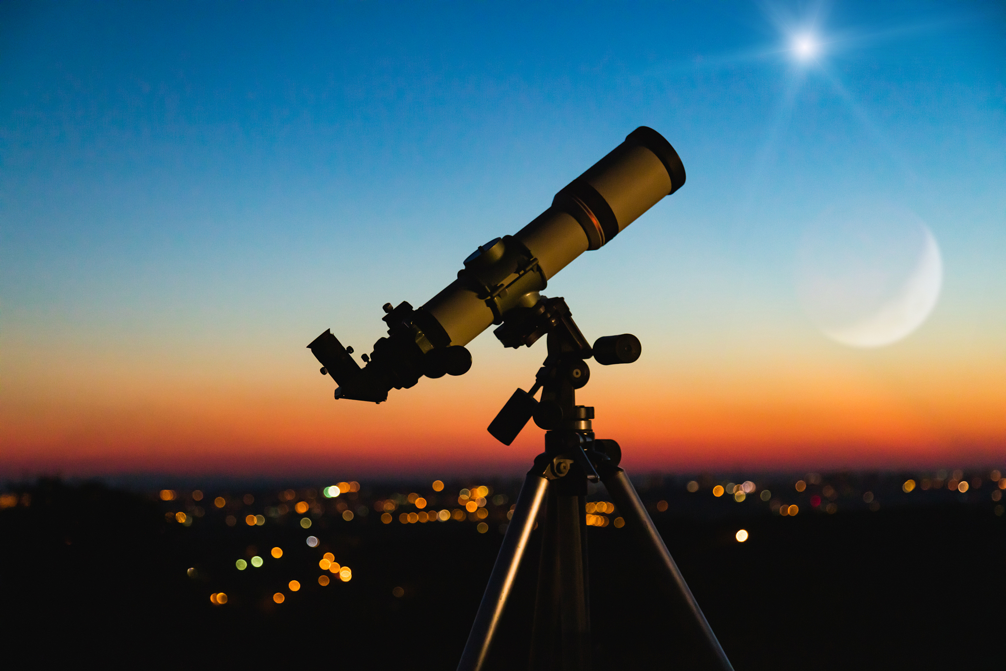 telescope silhouette and night sky with city lights in the backg