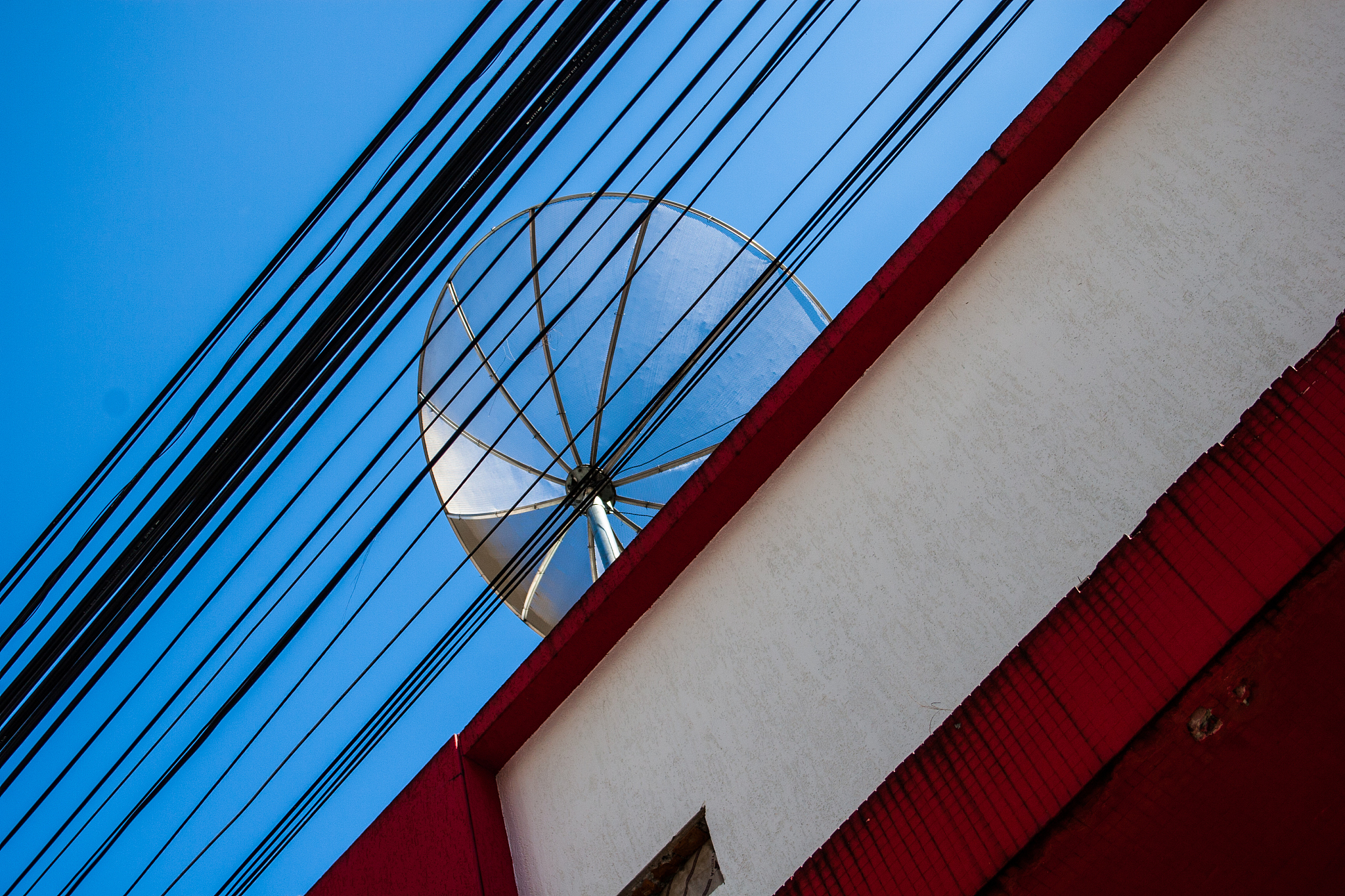 street wires and a roof antenna of a residence with blue sky bac