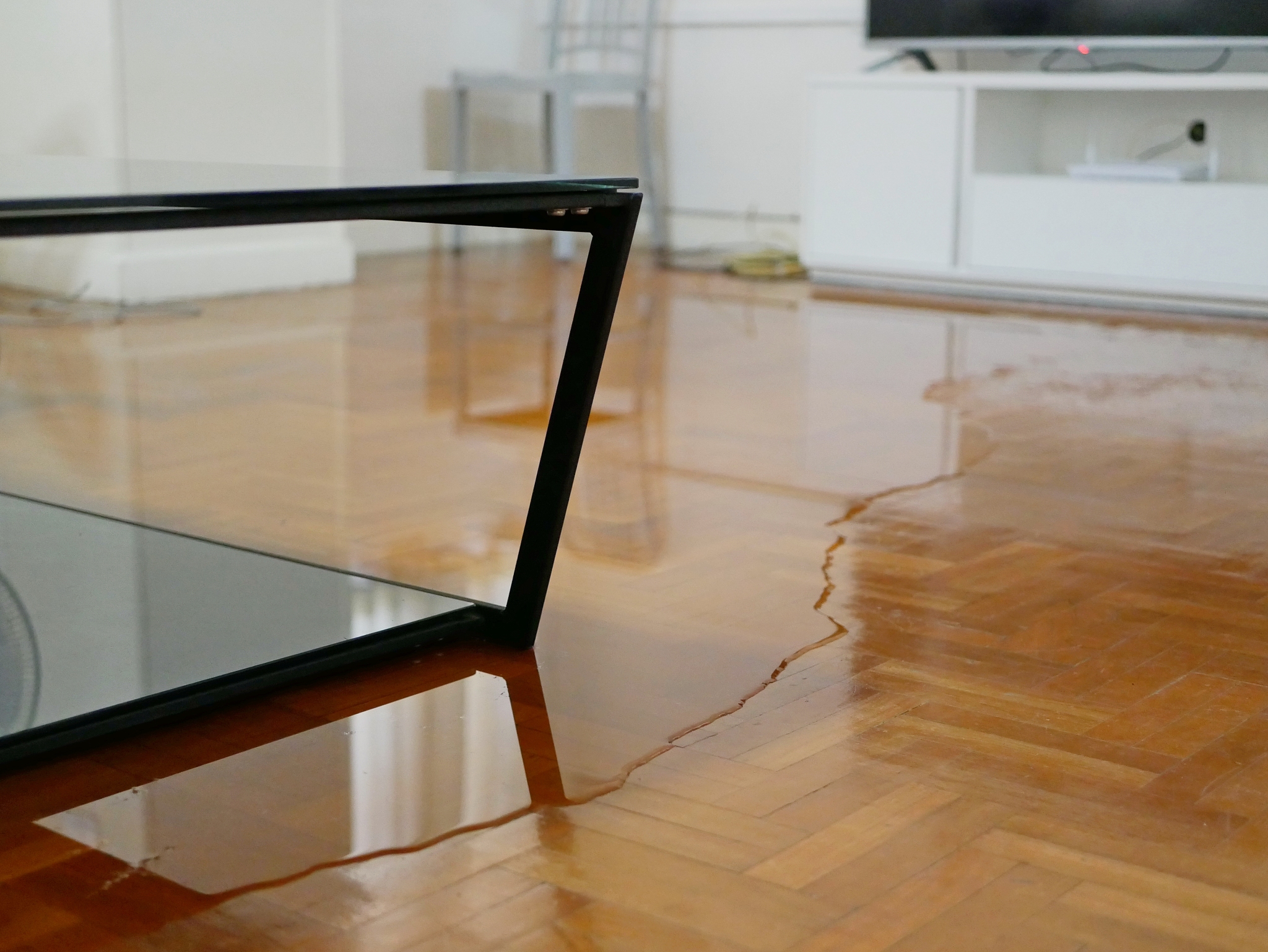 close up of water flooding on living room parquet floor in a hou