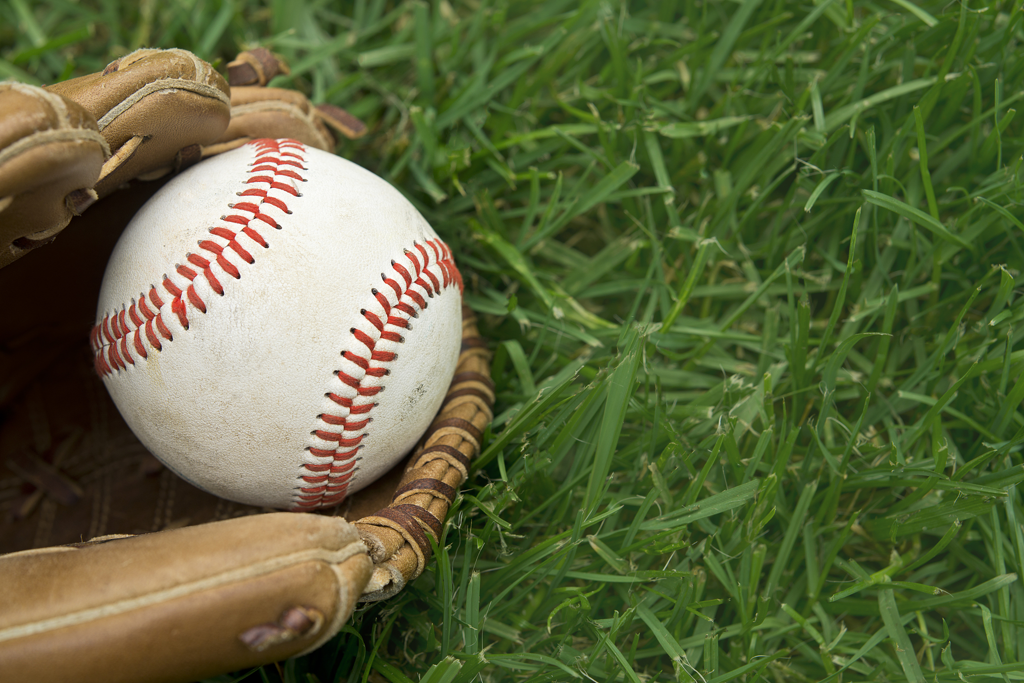 baseball on grass with glove.
